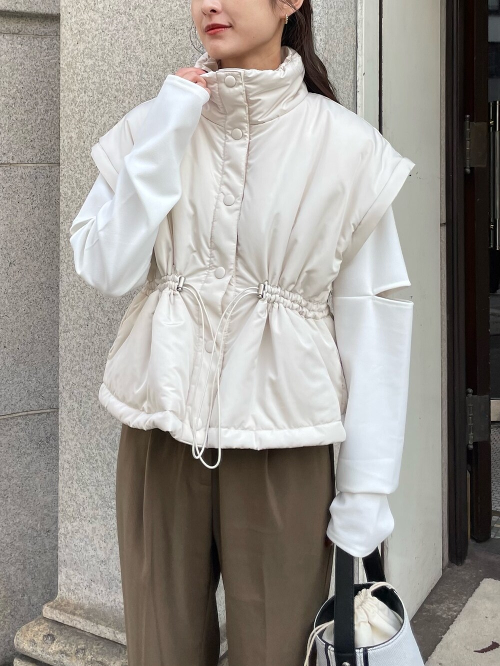 ホワイト系のダウンジャケット/コート、ホワイト系のTシャツ/カットソーを着用したレディースの秋コーディネートの2枚目の写真