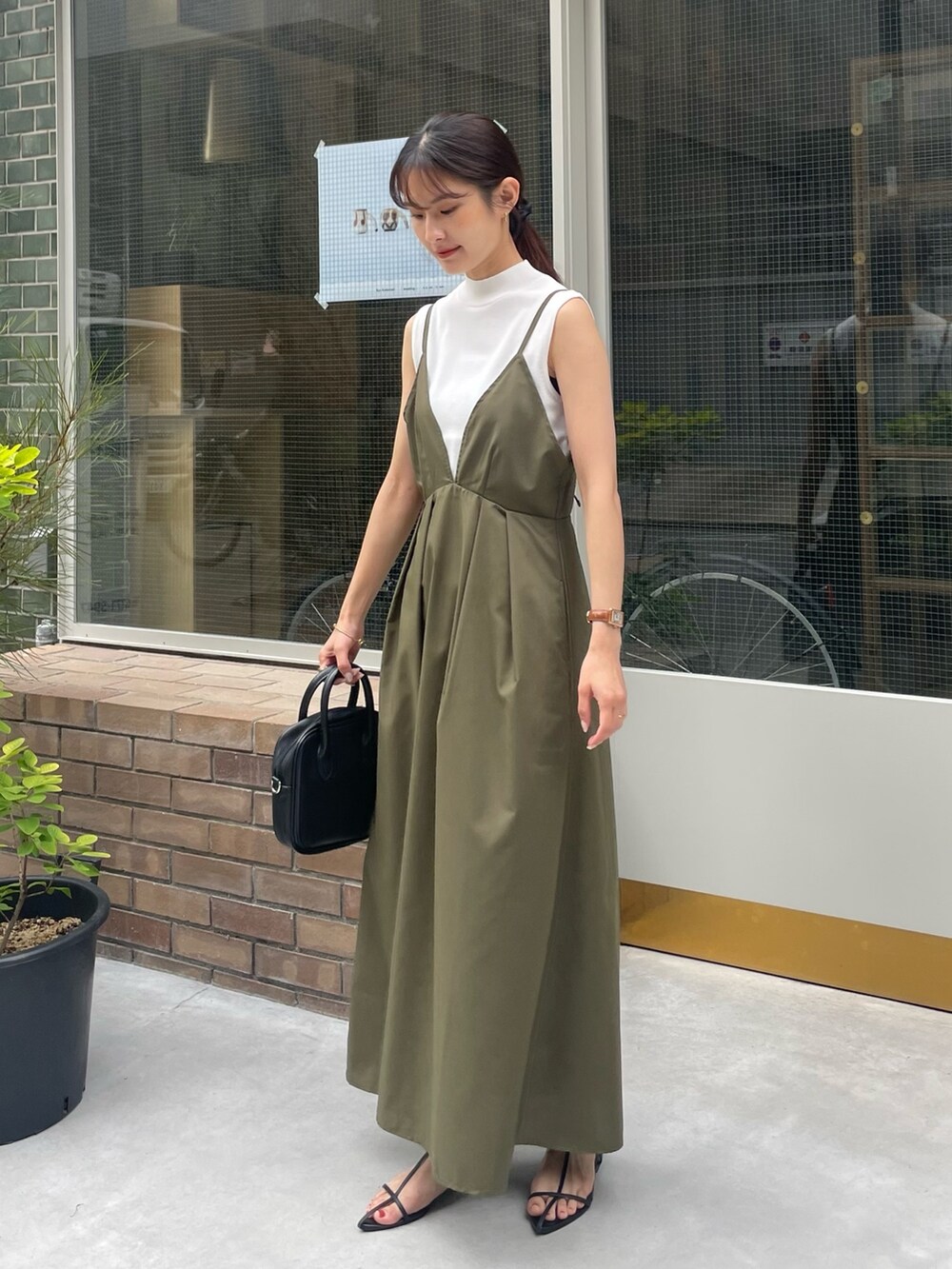 グリーン系のワンピース、ホワイト系のニット/セーターを着用したレディースの夏コーディネートの2枚目の写真