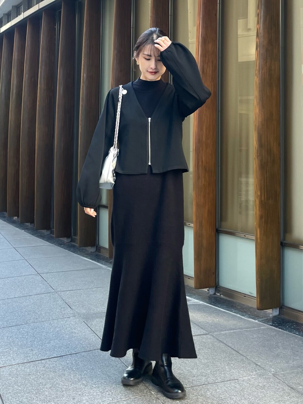 ブラック系のノーカラージャケット、シルバー系のショルダーバッグを着用したレディースの冬コーディネートの2枚目の写真