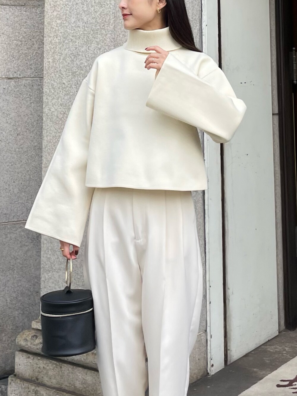 ホワイト系のニット/セーター、ブラック系のローファーを着用したレディースの秋コーディネートの2枚目の写真