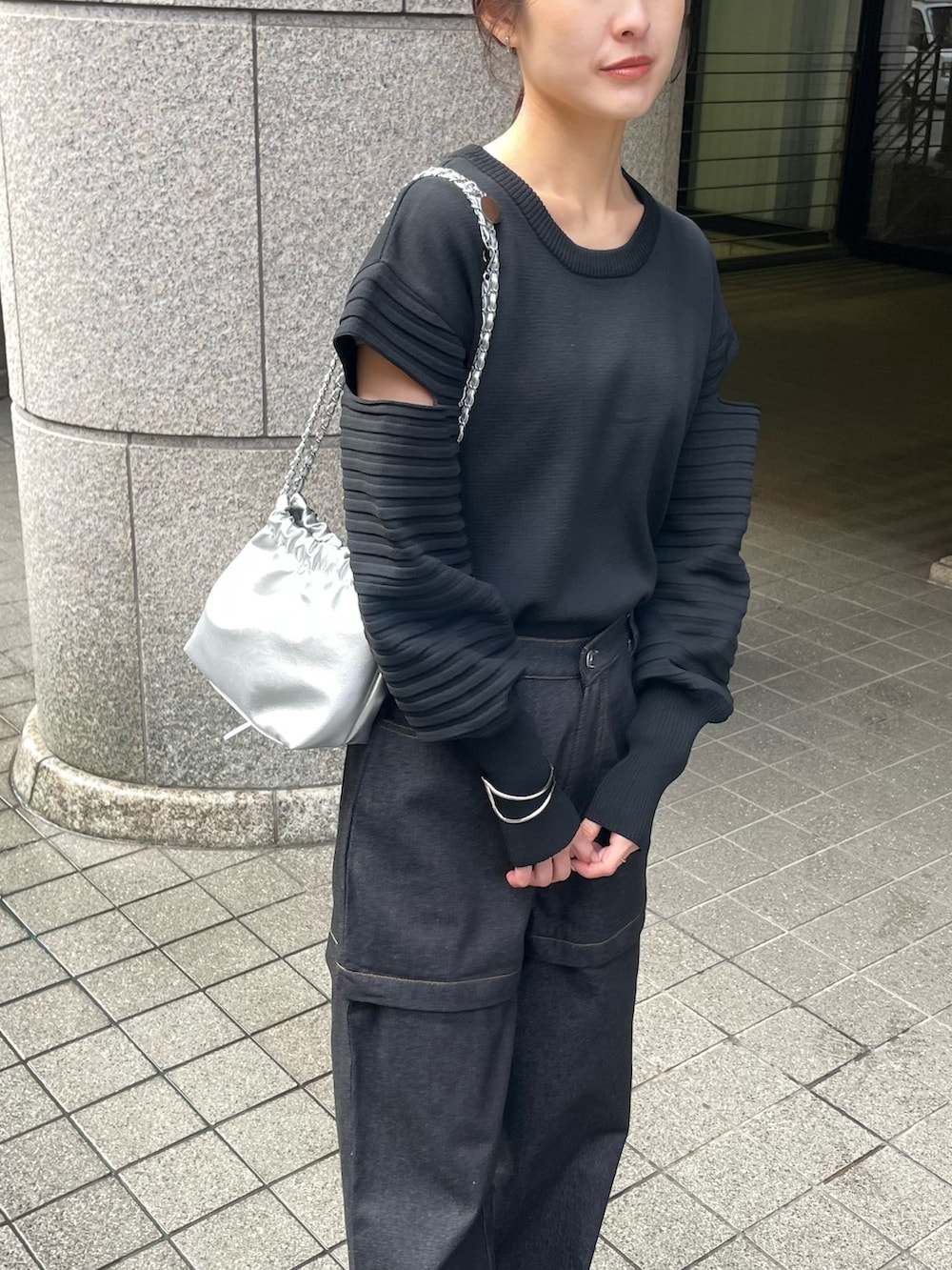 ブラック系のニット/セーター、ブラック系のデニムパンツを着用したレディースの春コーディネートの2枚目の写真