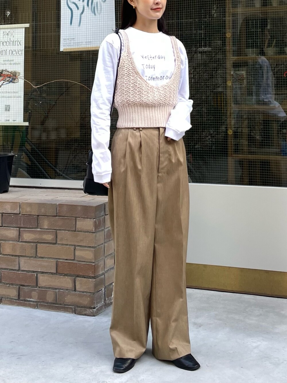 ホワイト系のTシャツ/カットソー、ホワイト系のニット/セーター、ベージュ系のスラックスを着用したレディースの春コーディネートの2枚目の写真