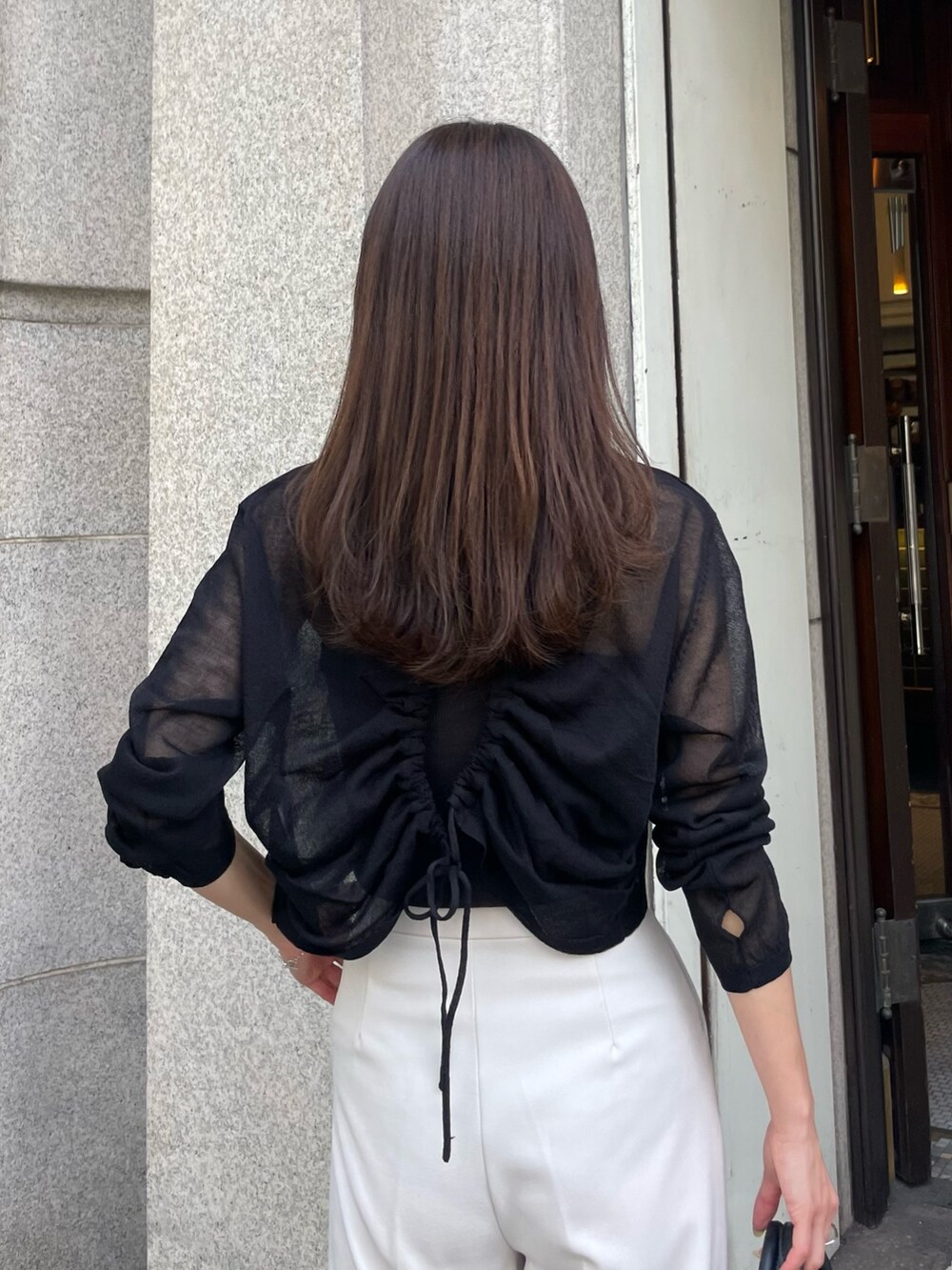 ブラック系のニット/セーター、ホワイト系のその他パンツを着用したレディースの夏コーディネートの2枚目の写真