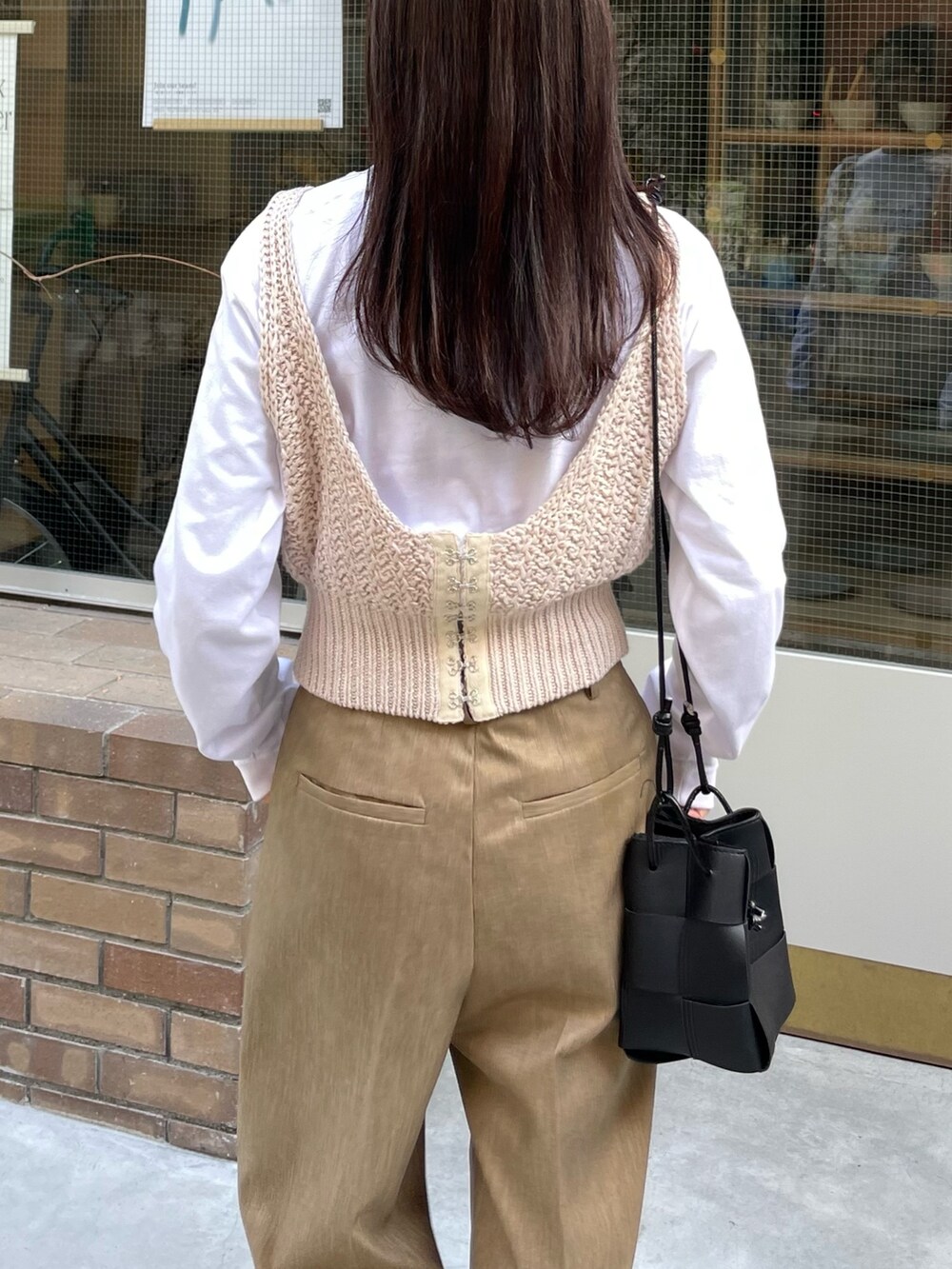 ホワイト系のTシャツ/カットソー、ホワイト系のニット/セーター、ベージュ系のスラックスを着用したレディースの春コーディネートの4枚目の写真