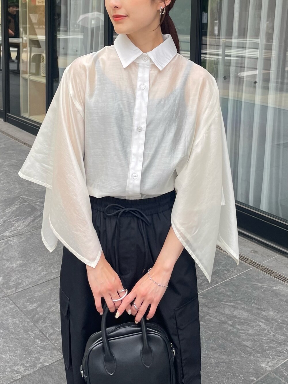 ブラック系のカーゴパンツを着用したレディースの夏コーディネートの2枚目の写真