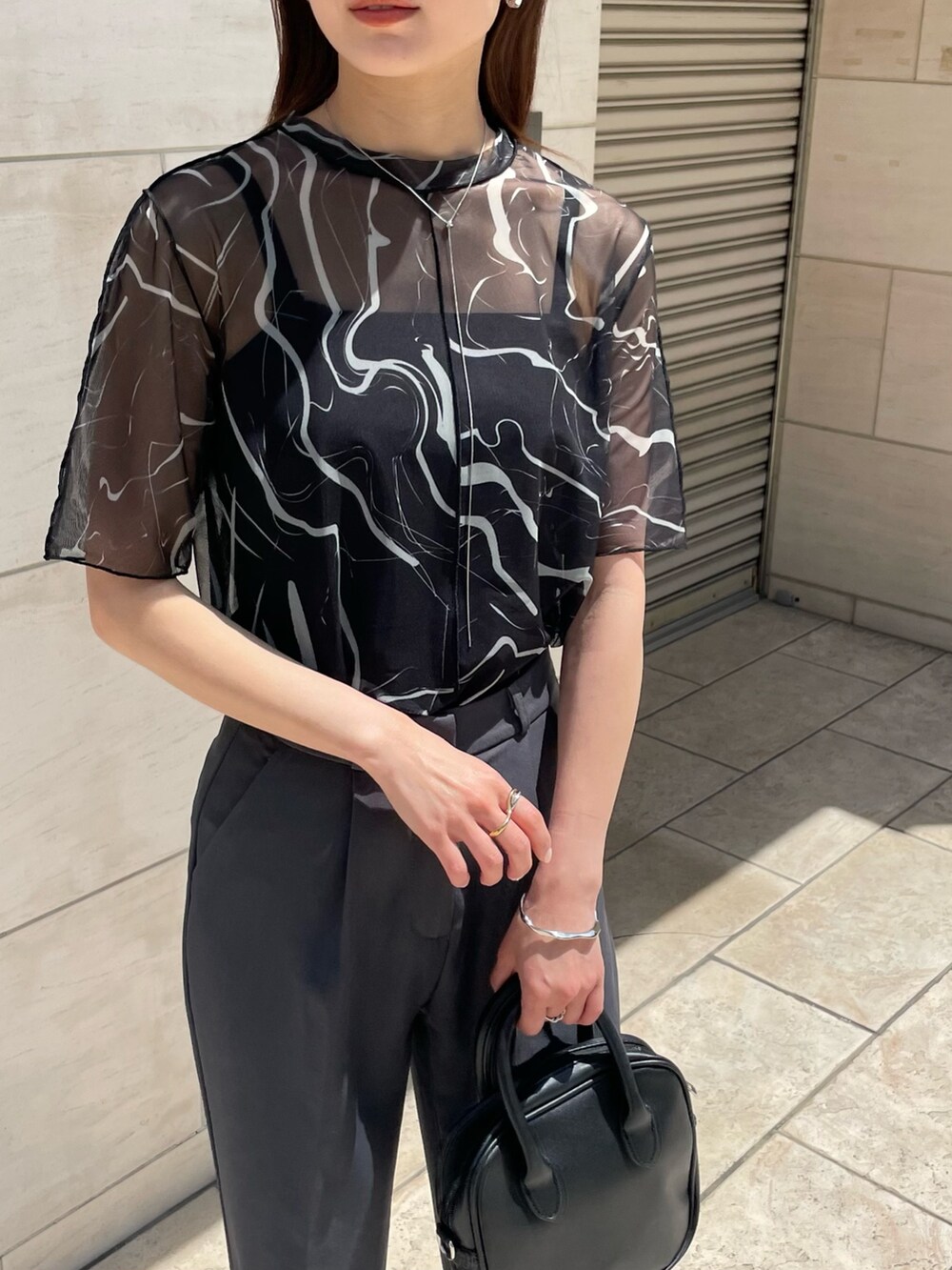 ブラック系のTシャツ/カットソー、シルバー系のネックレス、シルバー系のピアス（両耳用）を着用したレディースの春コーディネートの2枚目の写真