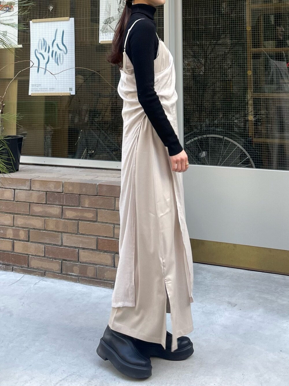 ベージュ系のワンピースを着用したレディースの冬コーディネートの2枚目の写真