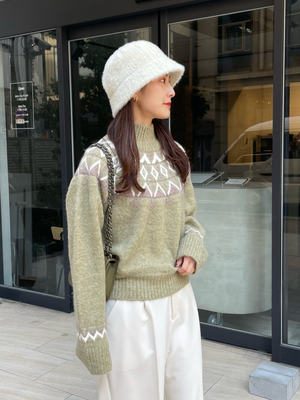 グリーン系のニット/セーター、ホワイト系のその他パンツを着用したレディースの秋コーディネートの2枚目の写真