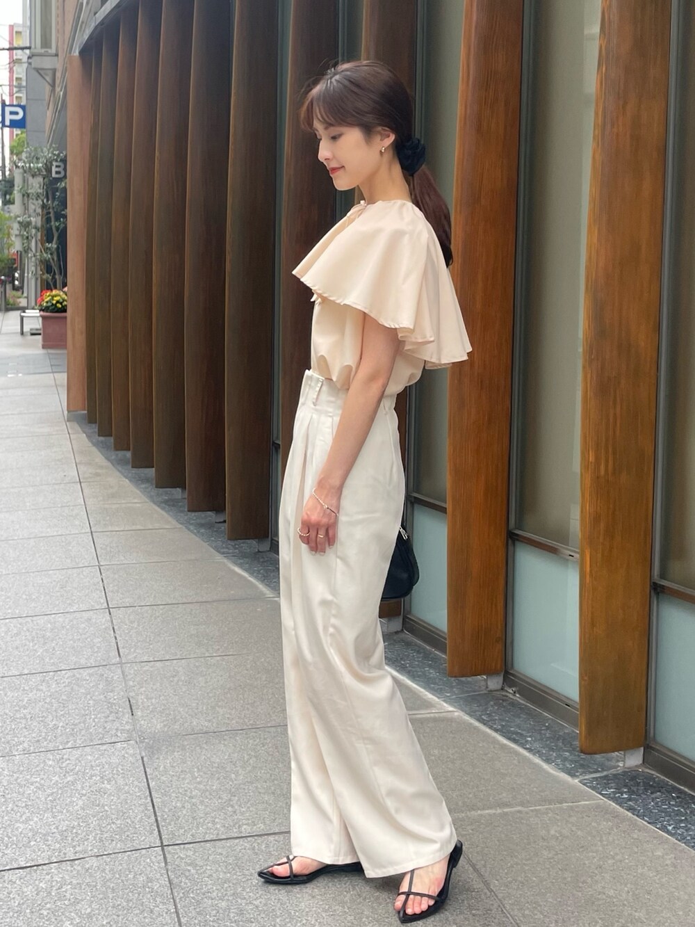 ベージュ系のシャツ/ブラウスを着用したレディースの夏コーディネートの2枚目の写真