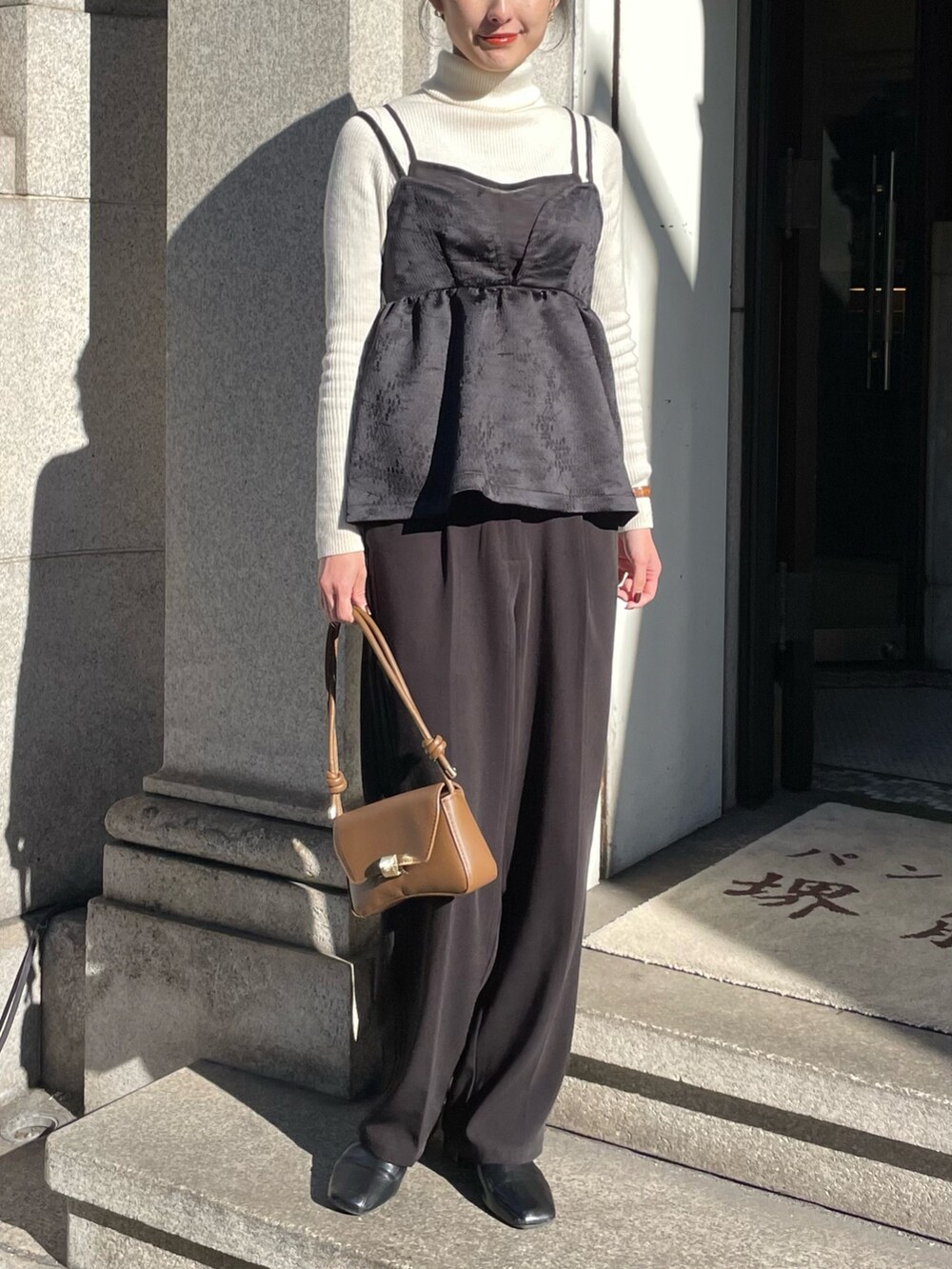 ブラック系のキャミソール、ホワイト系のニット/セーターを着用したレディースの冬コーディネートの2枚目の写真