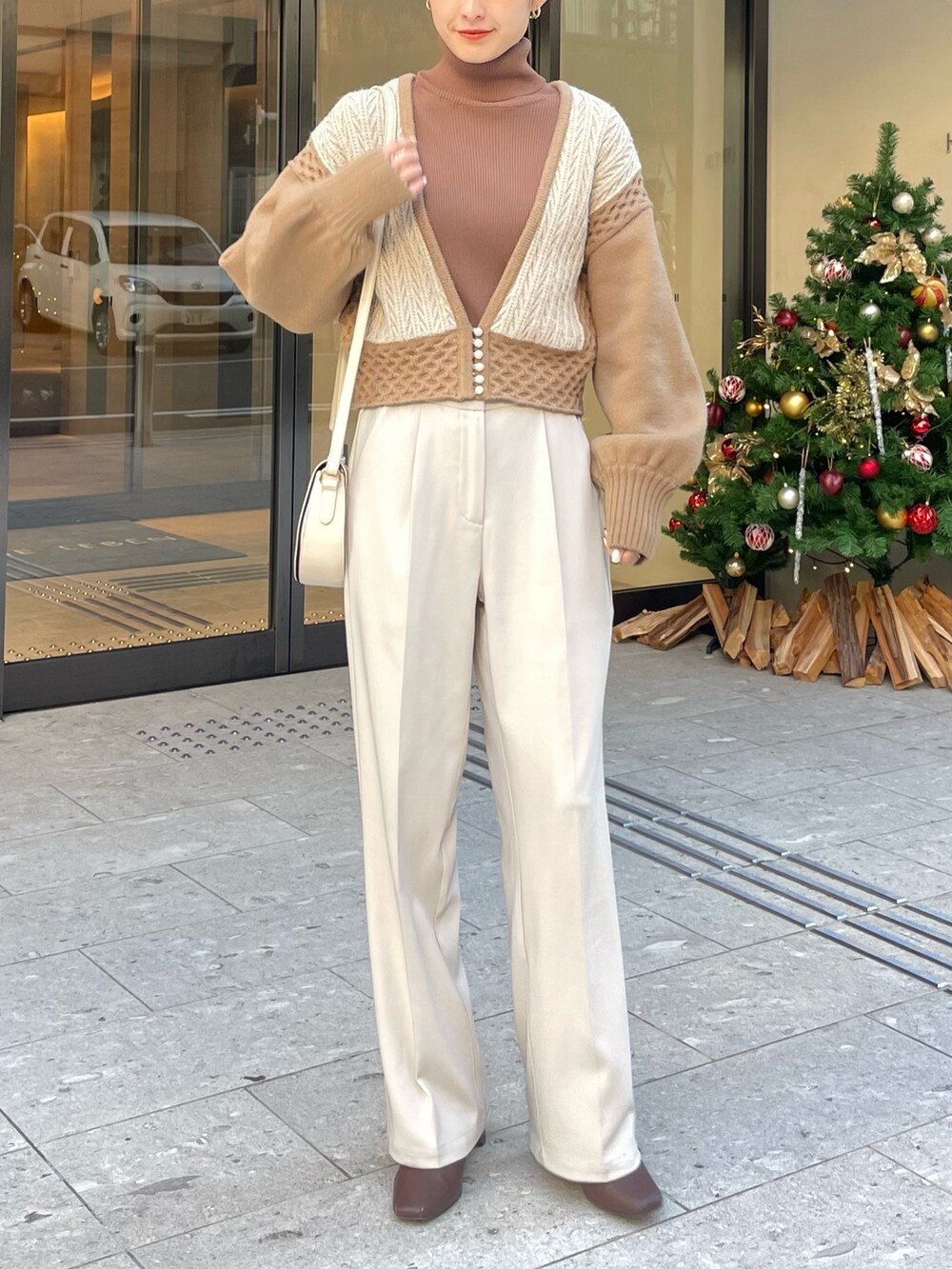 ブラウン系のブーツ、ベージュ系のニット/セーター、ブラウン系のニット/セーターを着用したレディースの秋コーディネートの2枚目の写真