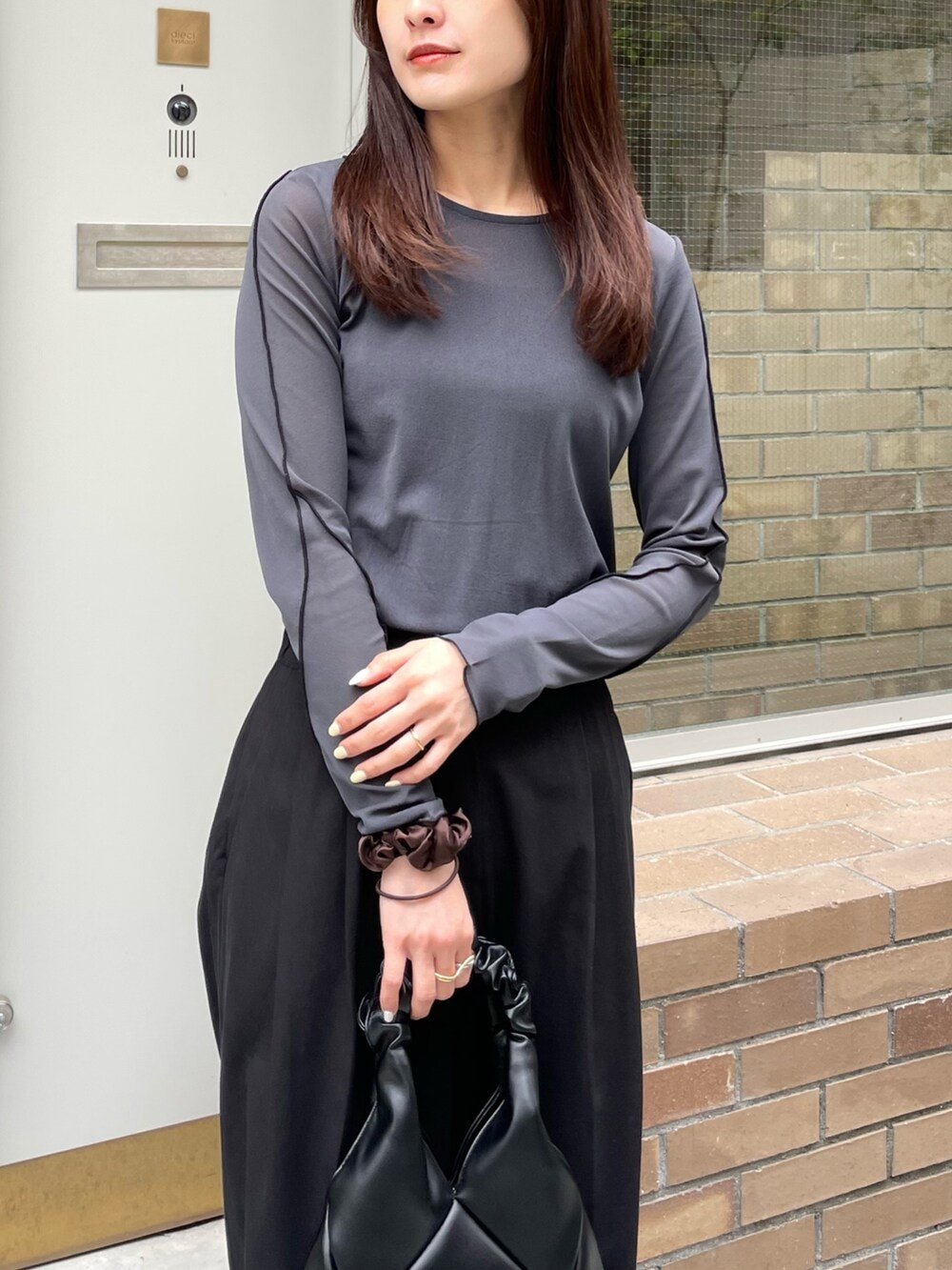 グレー系のTシャツ/カットソー、ブラック系のスラックス、ブラック系のバッグを着用したレディースの春コーディネートの2枚目の写真