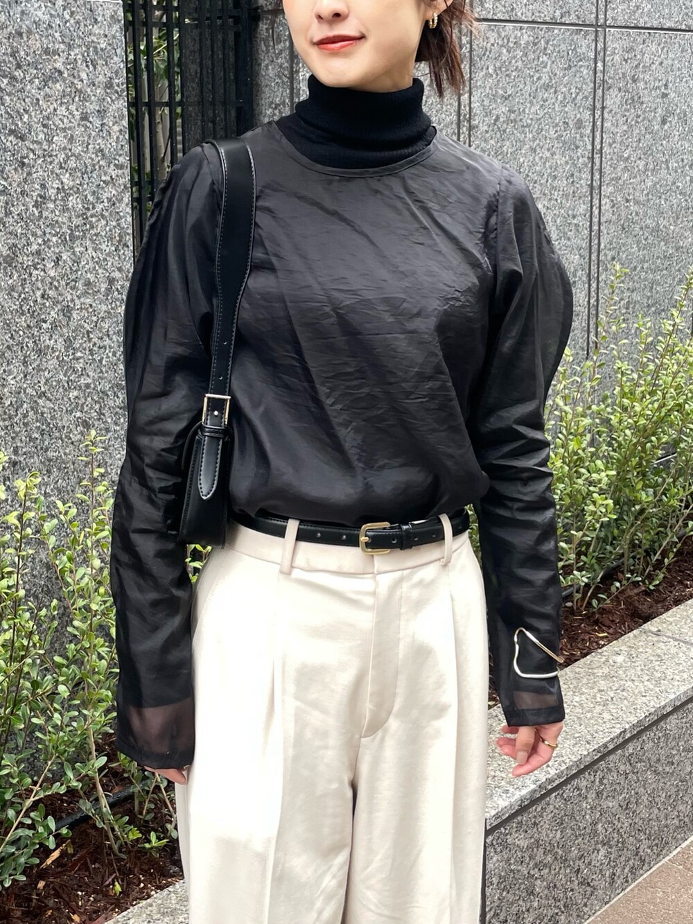 ホワイト系のパンツ、ブラック系のシャツ/ブラウス、シルバー系のバングル/リストバンドを着用したレディースの冬コーディネートの2枚目の写真