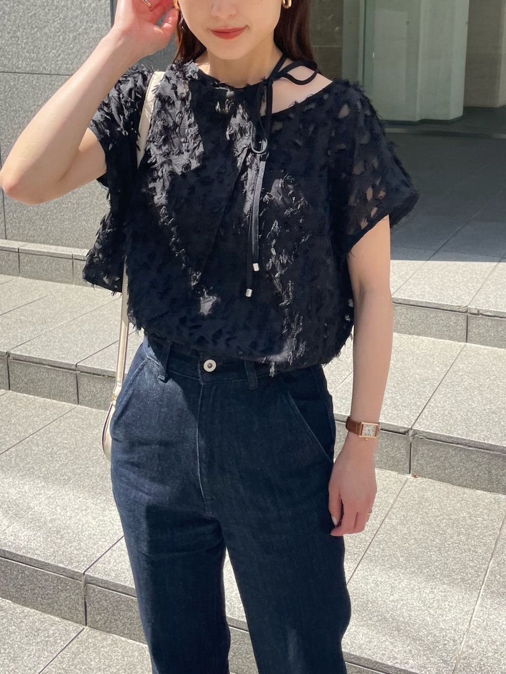 ブラック系のシャツ/ブラウス、ブルー系のデニムパンツ、ベージュ系のサンダルを着用したレディースの春コーディネートの2枚目の写真