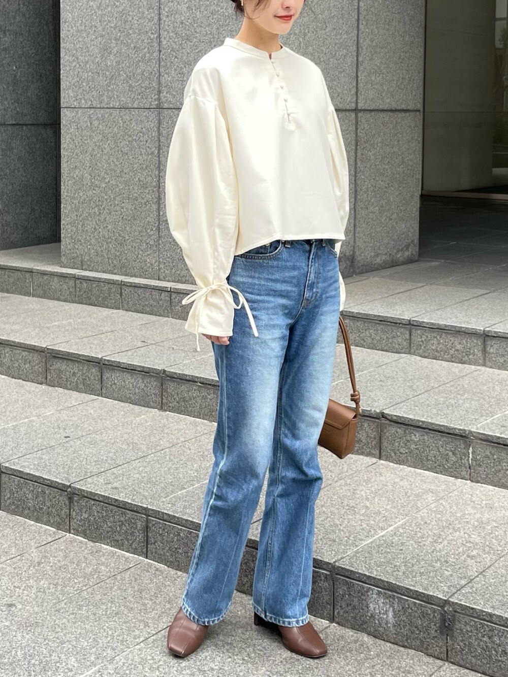 ホワイト系のシャツ/ブラウス、ブラウン系のハンドバッグ、ブラウン系のブーツを着用したレディースの冬コーディネートの2枚目の写真