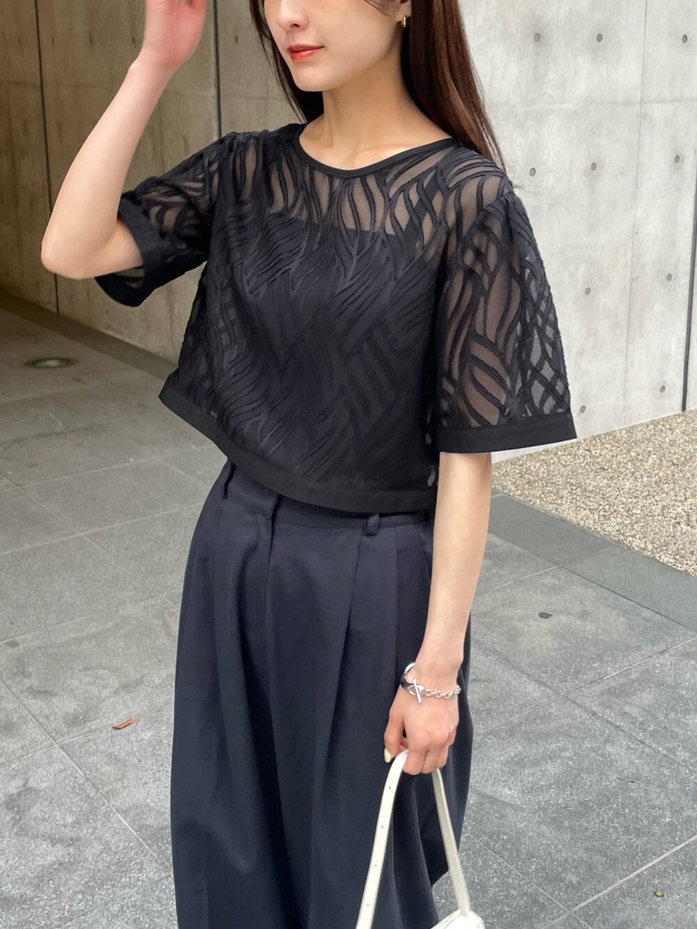 ブラック系のシャツ/ブラウス、ブルー系のスラックスを着用したレディースの春コーディネートの3枚目の写真