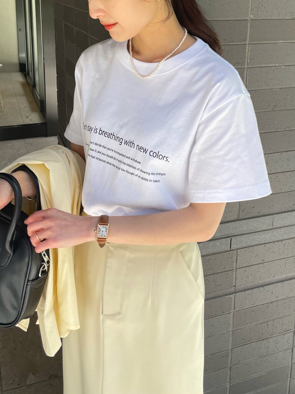 ホワイト系のTシャツ/カットソー、ホワイト系のスカート、イエロー系のシャツ/ブラウスを着用したレディースの春コーディネートの2枚目の写真