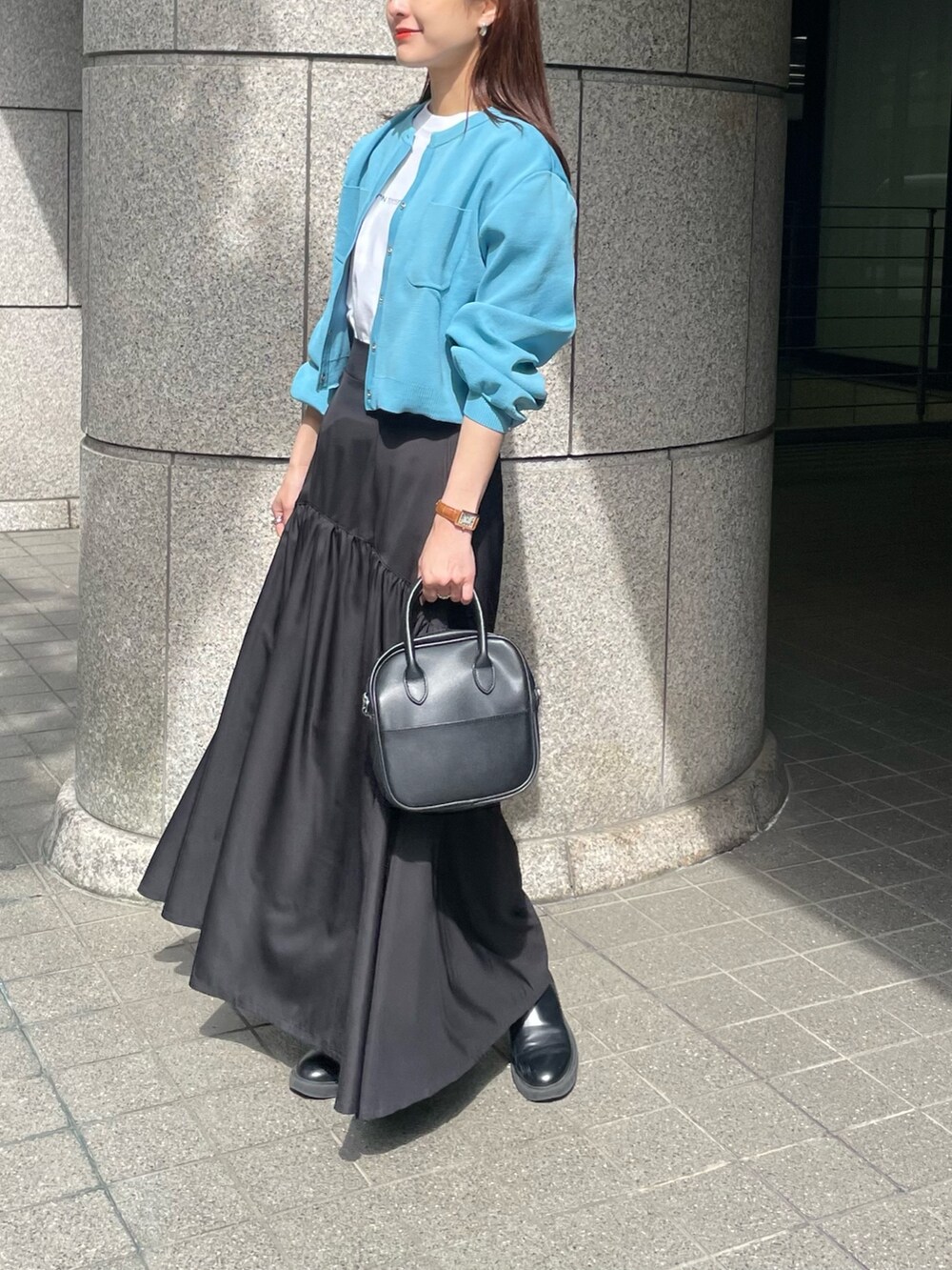 ブルー系のカーディガン/ボレロ、ホワイト系のTシャツ/カットソー、ブラック系のスカートを着用したレディースの春コーディネートの2枚目の写真