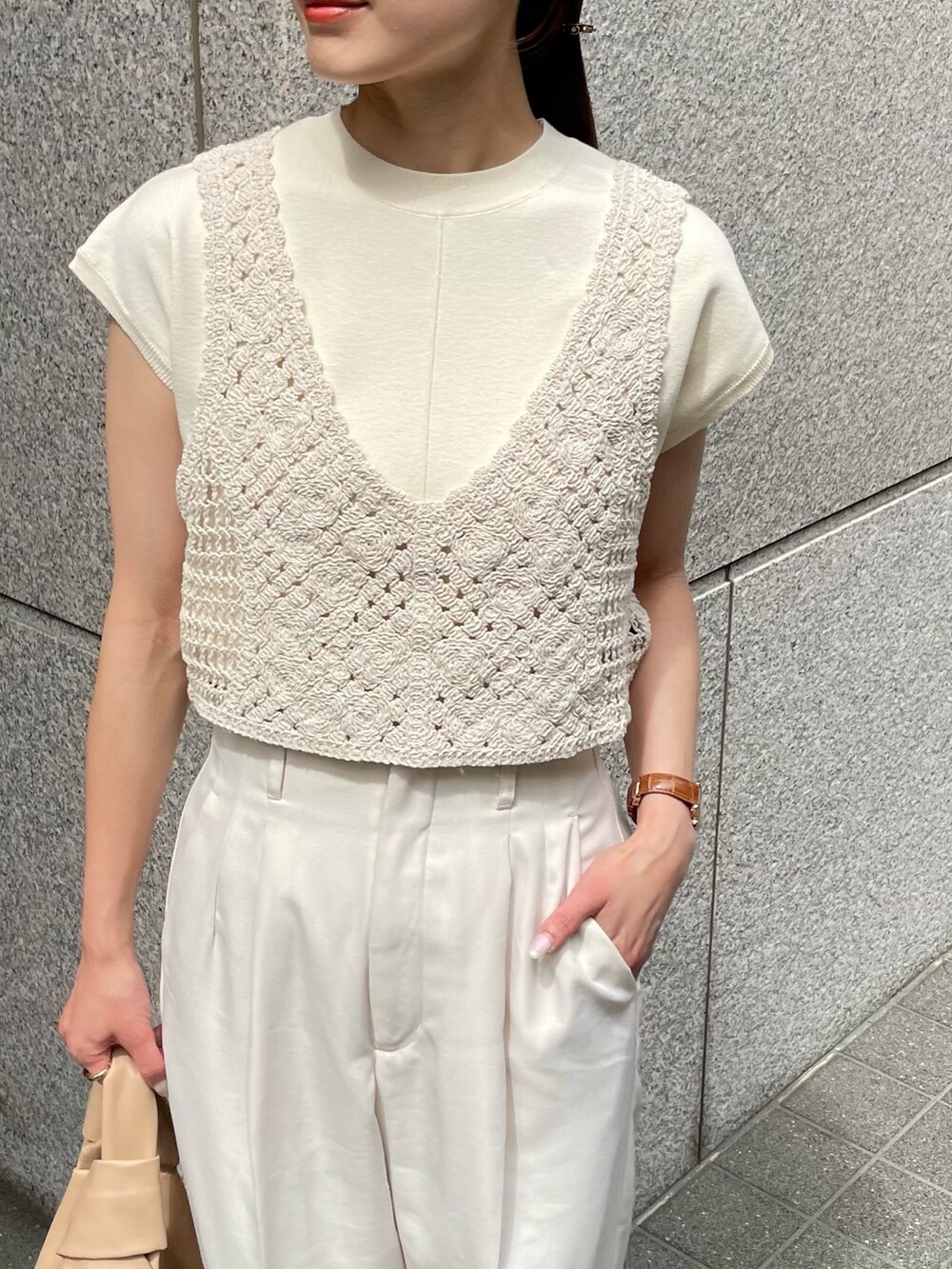 ホワイト系のサンダル、ホワイト系のニット/セーター、ベージュ系のベストを着用したレディースの夏コーディネートの2枚目の写真