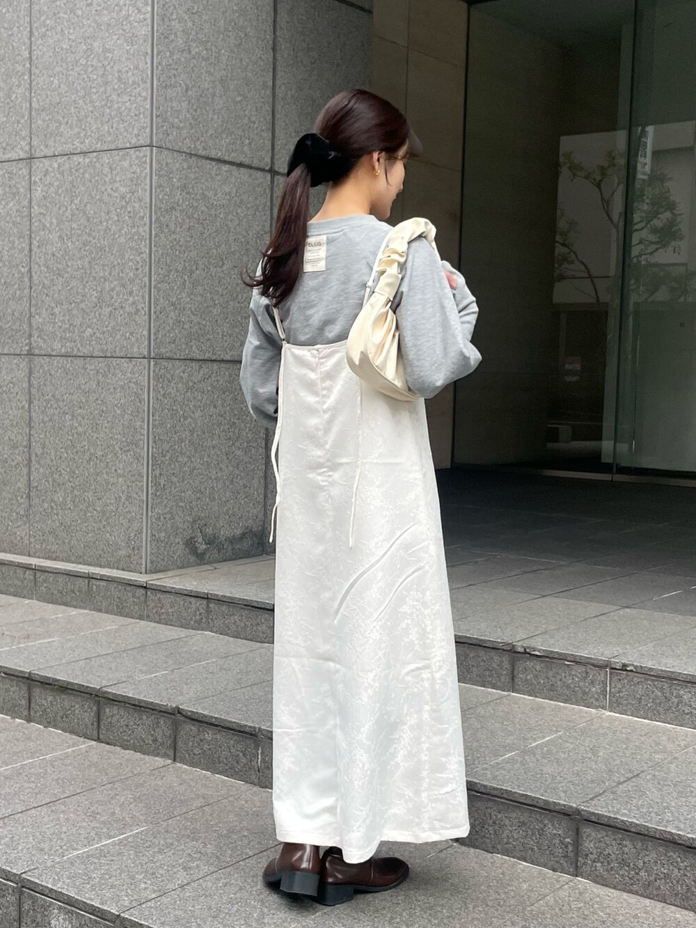 ホワイト系のワンピース、グレー系のTシャツ/カットソーを着用したレディースの春コーディネートの3枚目の写真