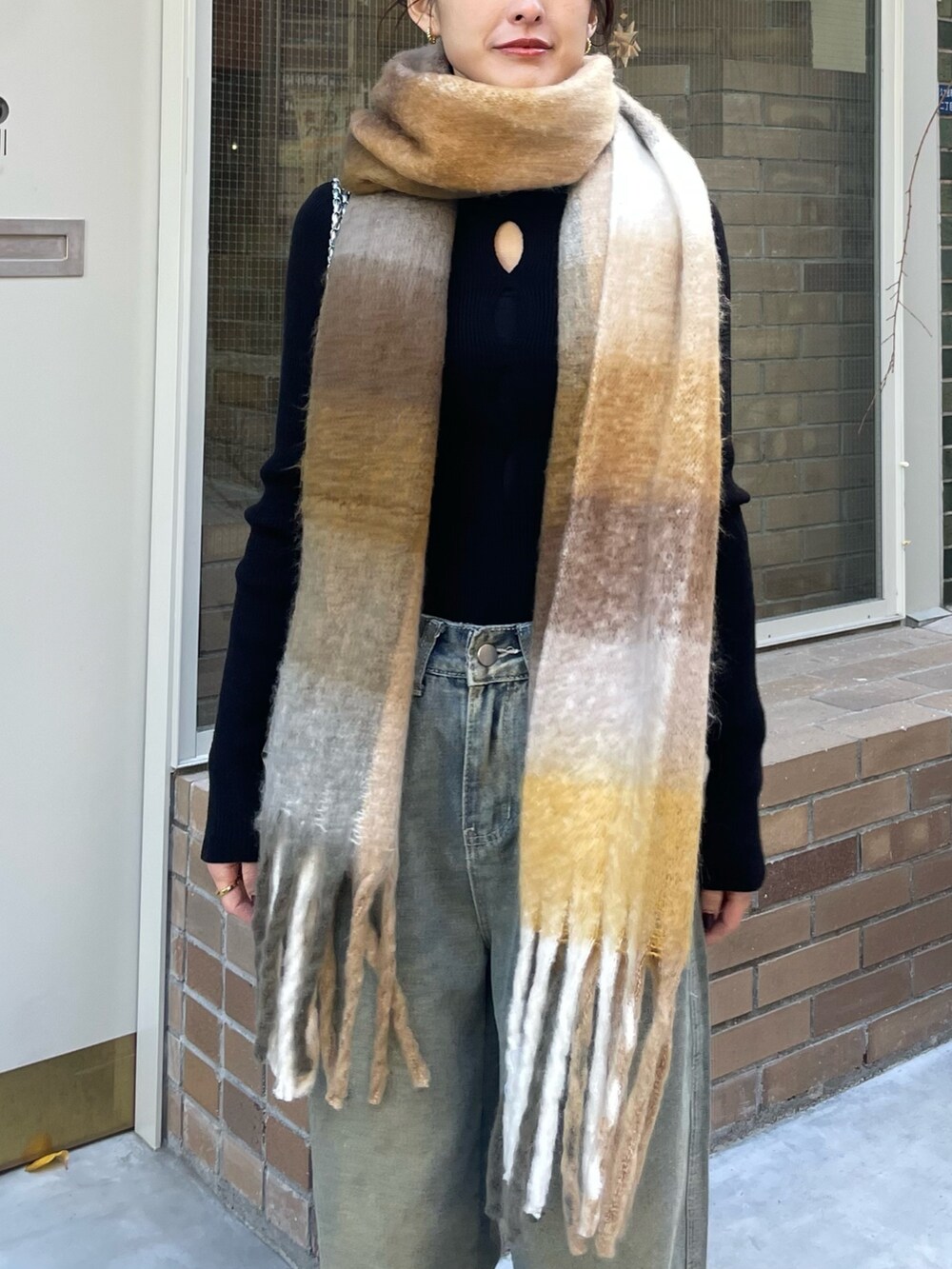 ベージュ系のマフラーを着用したレディースの冬コーディネートの3枚目の写真