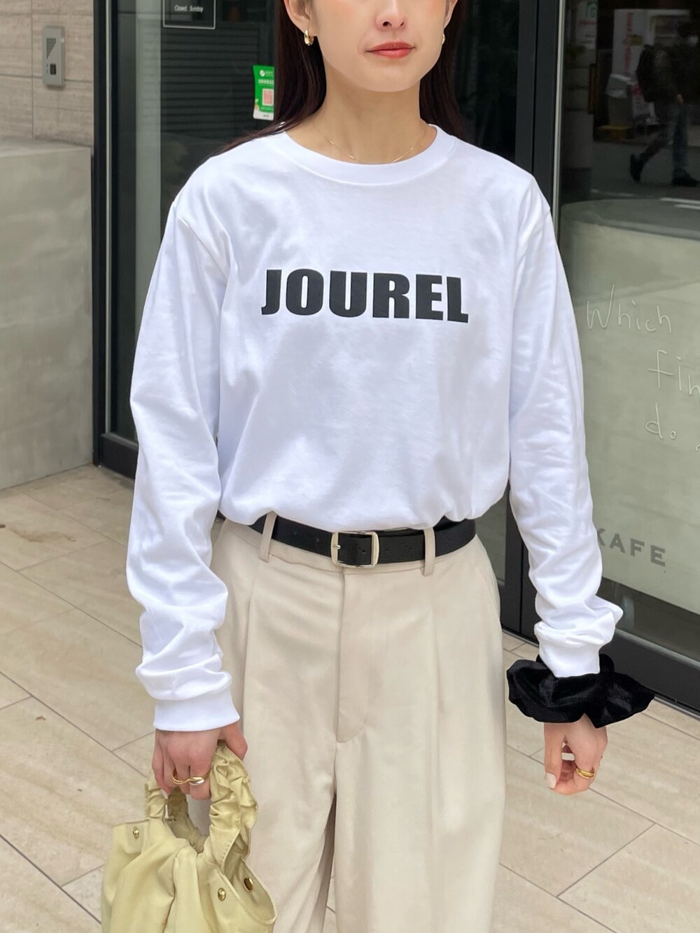 ホワイト系のTシャツ/カットソー、ホワイト系のパンツ、ベージュ系のバッグを着用したレディースの冬コーディネートの2枚目の写真