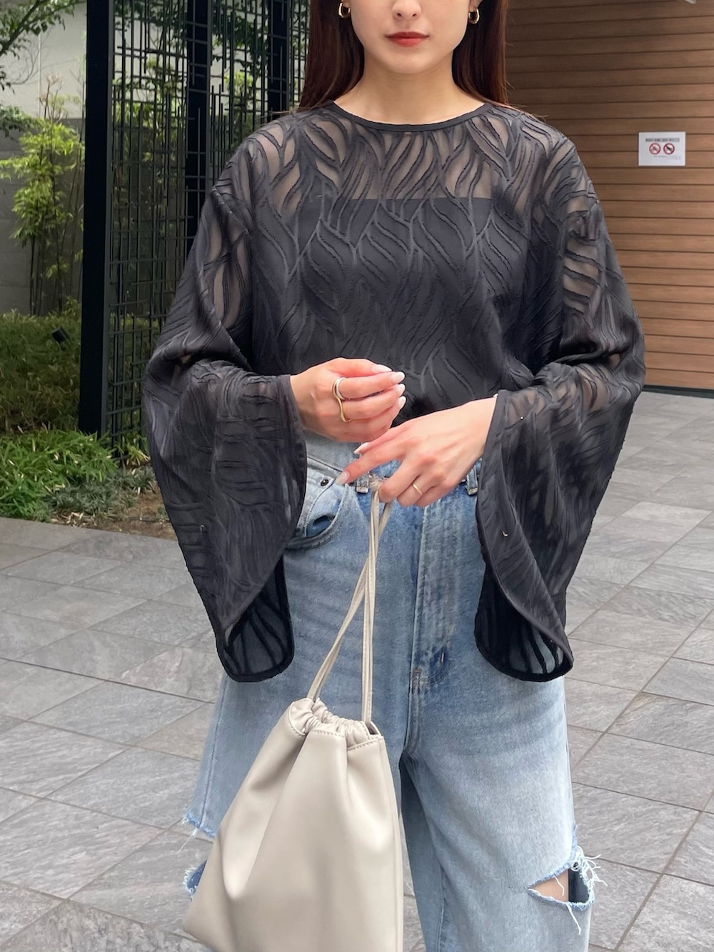 ブルー系のデニムパンツ、ブラック系のシャツ/ブラウス、ベージュ系のサンダルを着用したレディースの夏コーディネートの2枚目の写真