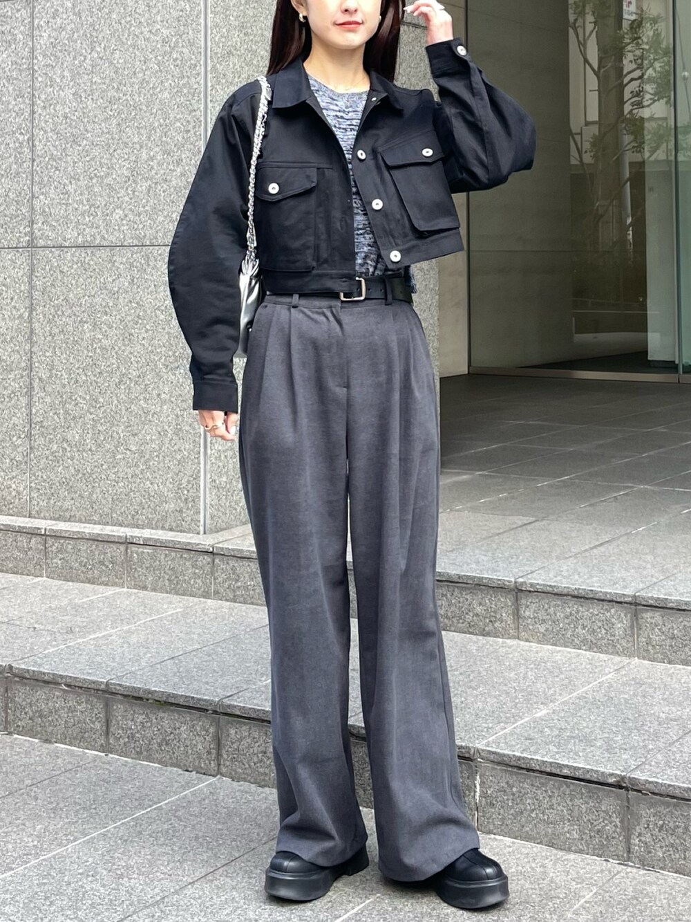 ブラック系のデニムジャケット、グレー系のニット/セーターを着用したレディースの冬コーディネートの2枚目の写真