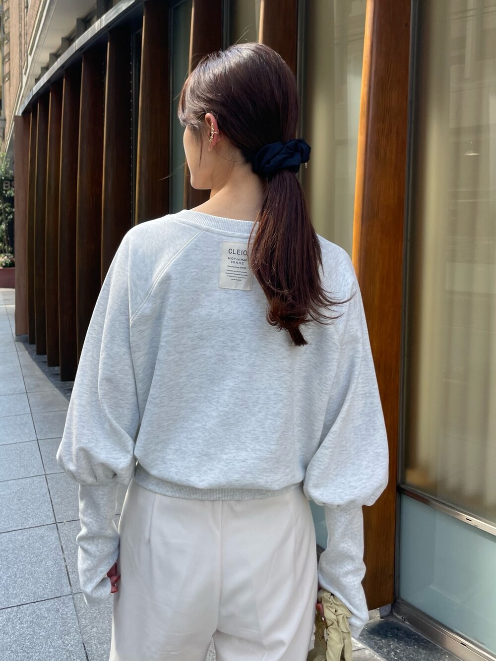 グレー系のTシャツ/カットソー、ベージュ系のバッグ、ホワイト系のスニーカーを着用したレディースの秋コーディネートの2枚目の写真