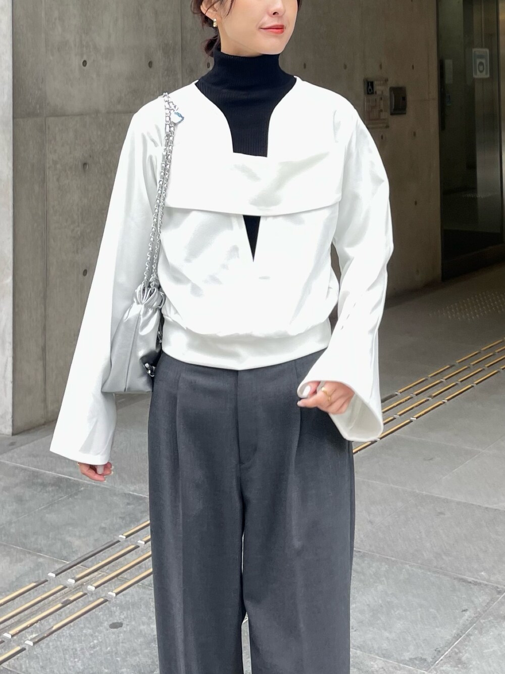 ホワイト系のTシャツ/カットソー、グレー系のパンツを着用したレディースの冬コーディネートの2枚目の写真