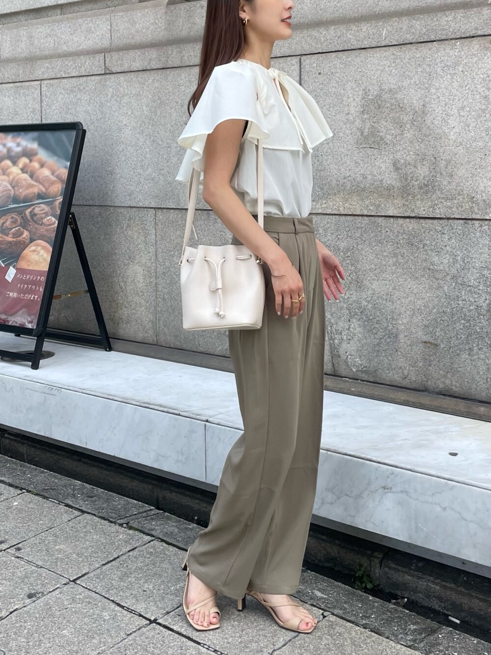 ベージュ系のサンダル、ホワイト系のシャツ/ブラウスを着用したレディースの夏コーディネートの2枚目の写真