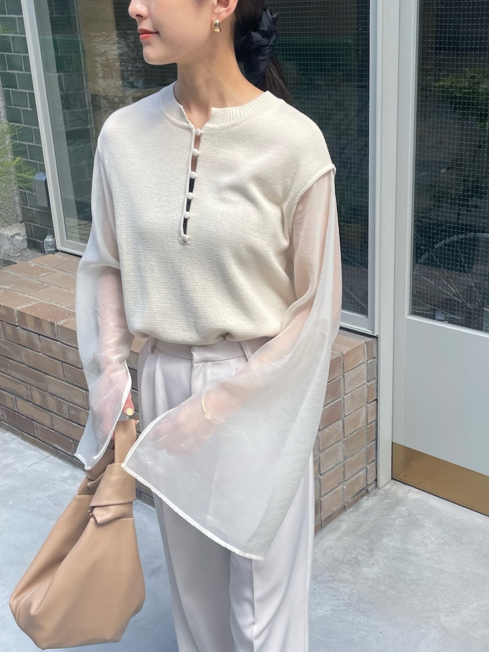 ホワイト系のニット/セーター、ホワイト系のその他パンツ、ホワイト系のサンダルを着用したレディースの夏コーディネートの2枚目の写真