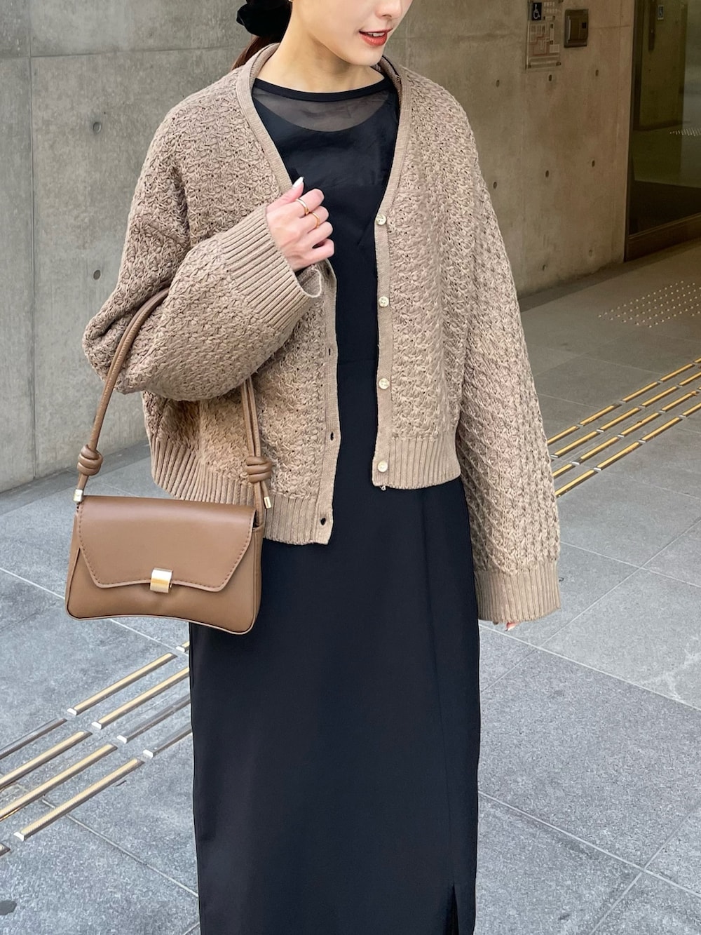 ベージュ系のカーディガン/ボレロ、ブラック系のドレスを着用したレディースの冬コーディネートの3枚目の写真