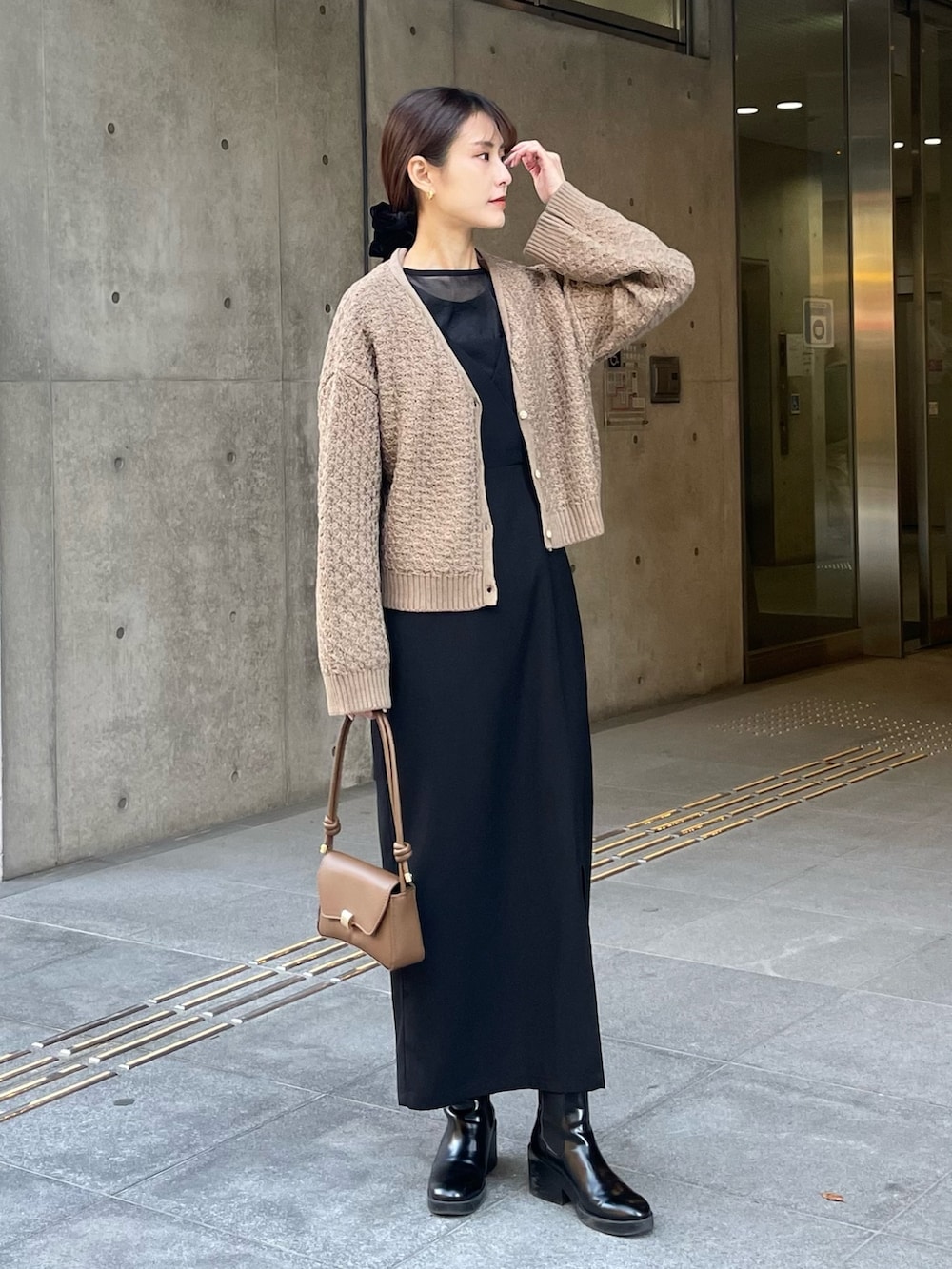 ベージュ系のカーディガン/ボレロ、ブラック系のドレスを着用したレディースの冬コーディネートの2枚目の写真