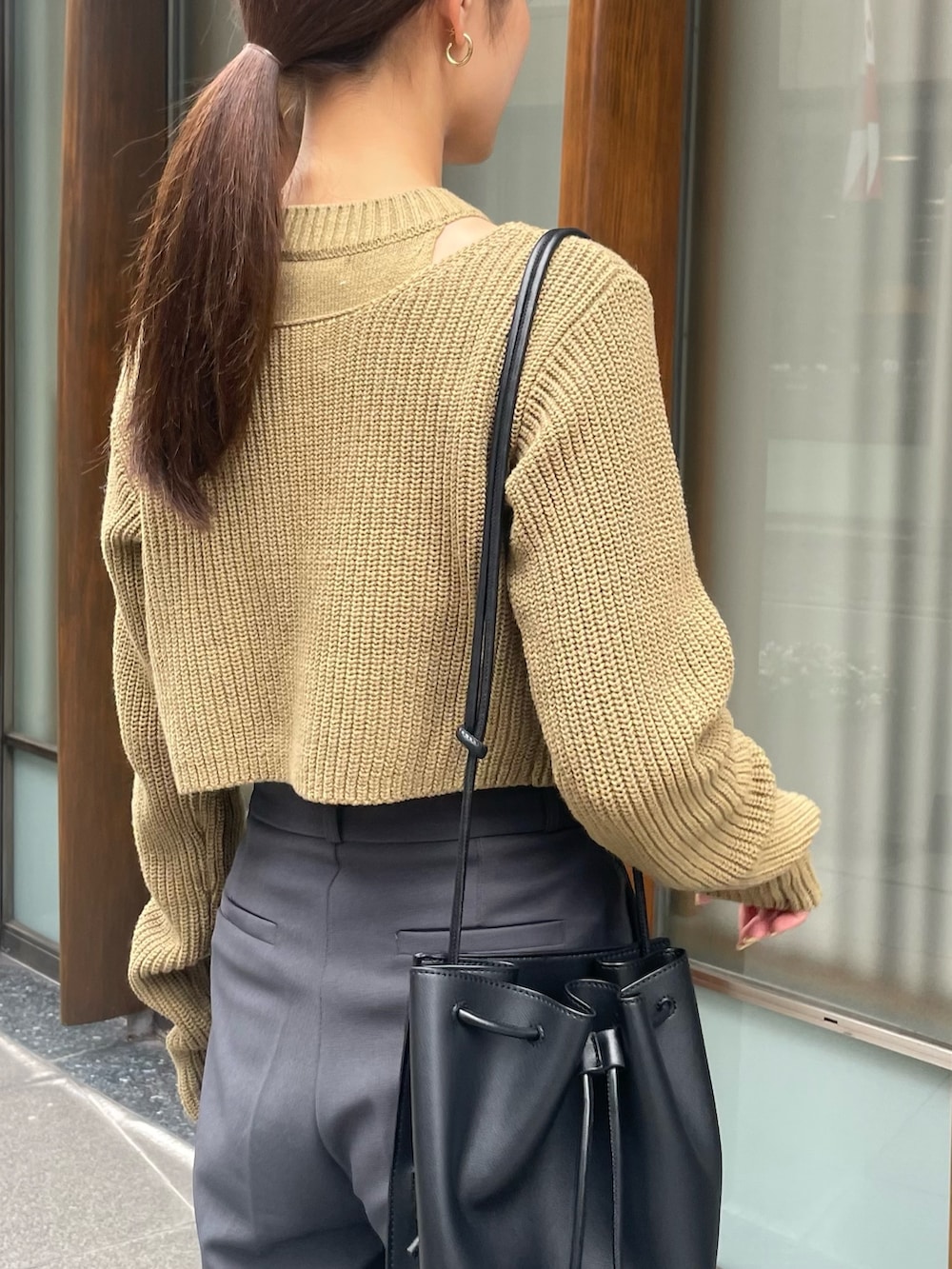 グリーン系のニット/セーターを着用したレディースの夏コーディネートの3枚目の写真