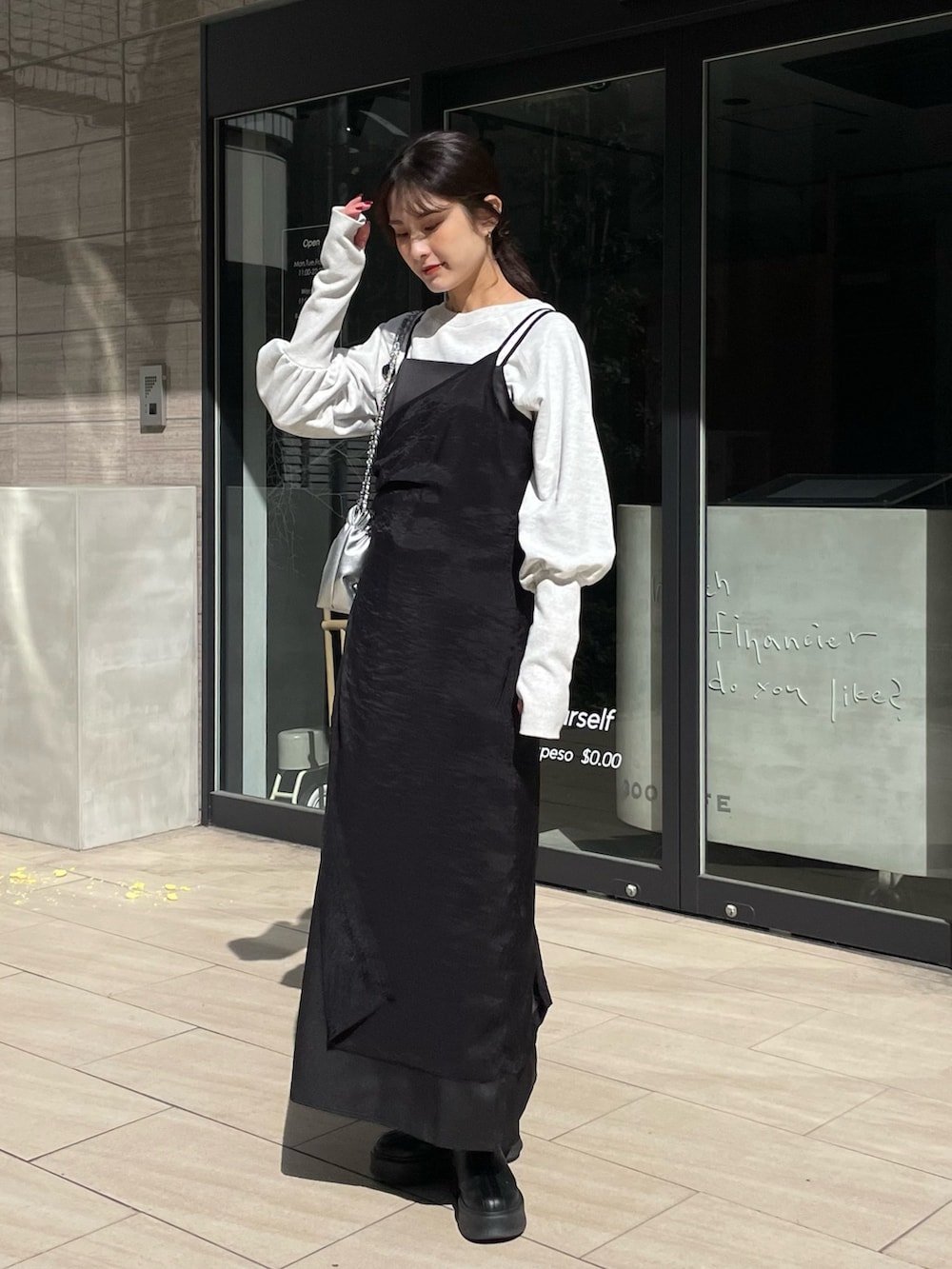 グレー系のTシャツ/カットソー、ブラック系のワンピースを着用したレディースの春コーディネートの2枚目の写真