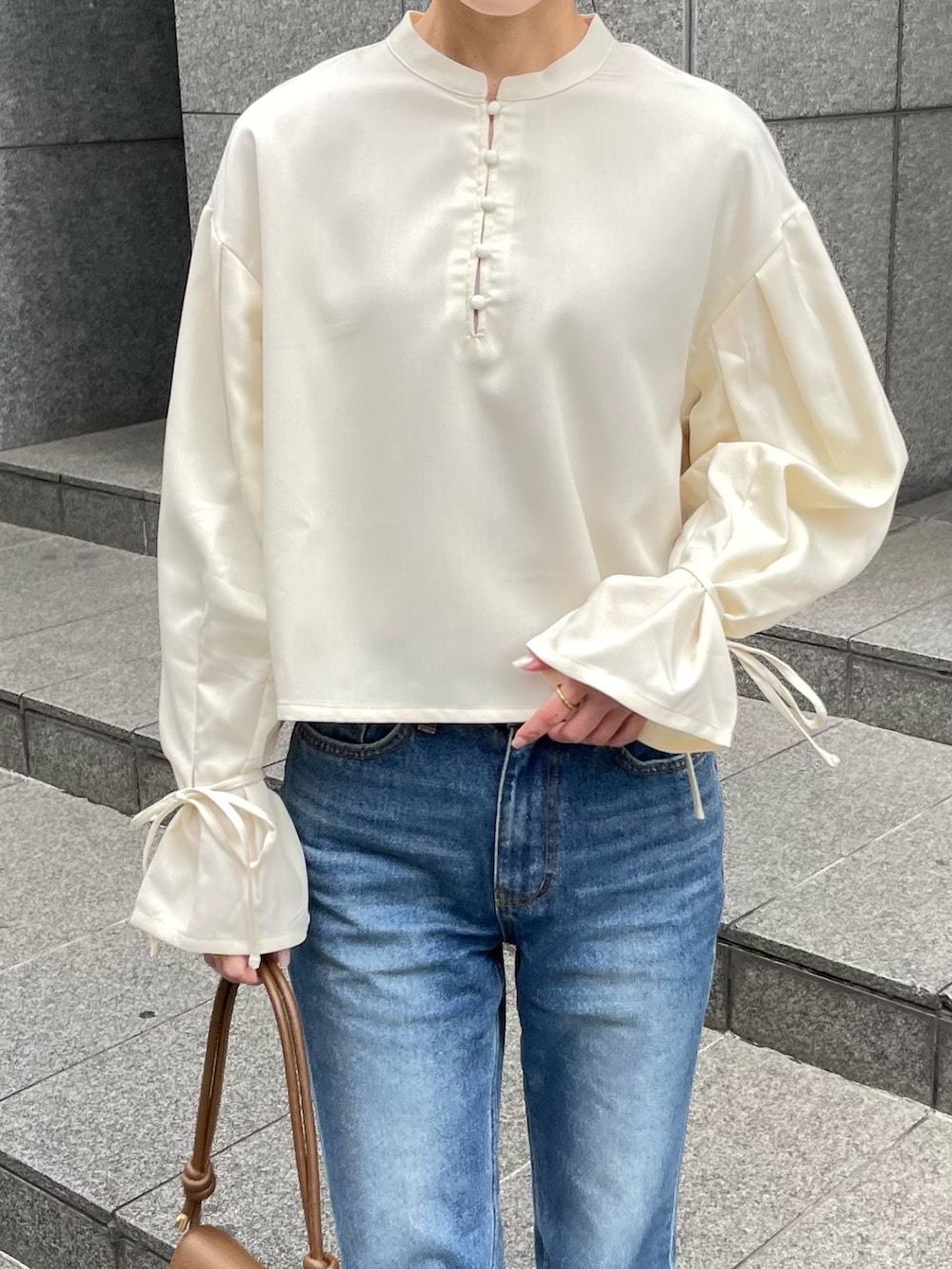 ホワイト系のシャツ/ブラウス、ブラウン系のハンドバッグ、ブラウン系のブーツを着用したレディースの冬コーディネートの3枚目の写真