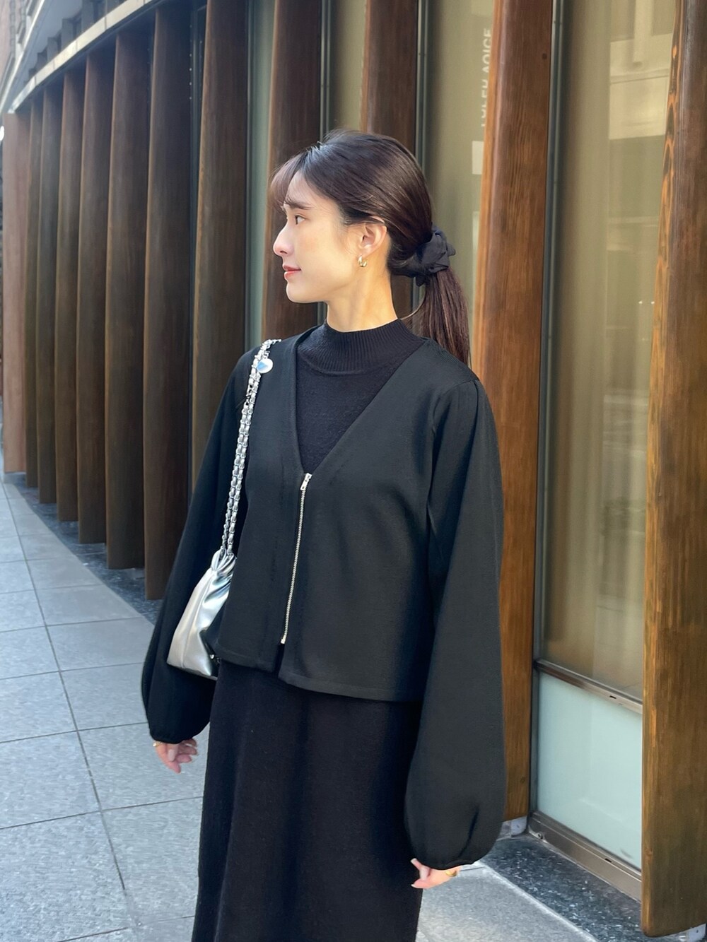 ブラック系のノーカラージャケット、シルバー系のショルダーバッグを着用したレディースの冬コーディネートの3枚目の写真