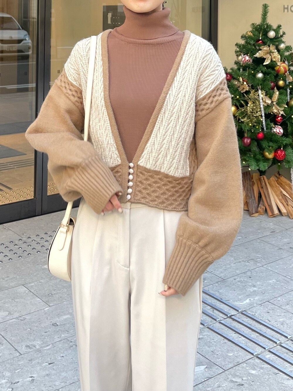 ブラウン系のブーツ、ベージュ系のニット/セーター、ブラウン系のニット/セーターを着用したレディースの秋コーディネートの3枚目の写真