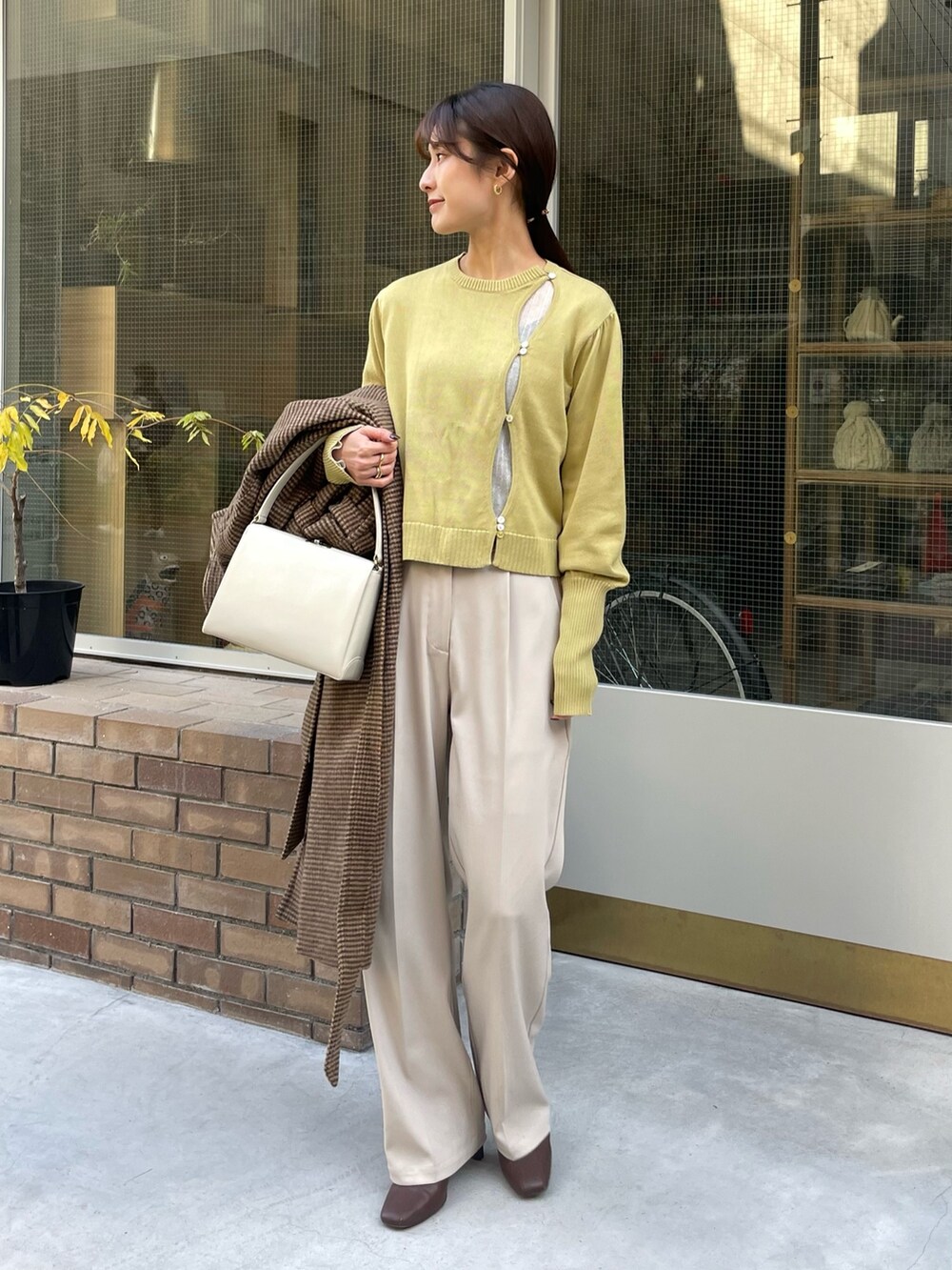 その他のステンカラーコート、ホワイト系のニット/セーター、グリーン系のニット/セーターを着用したレディースの冬コーディネートの2枚目の写真