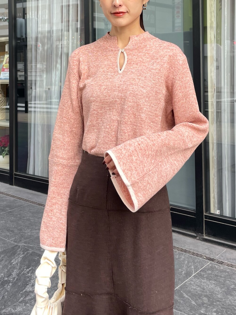 ピンク系のダウンジャケット/コート、ブラウン系のニット/セーターを着用したレディースの冬コーディネートの2枚目の写真