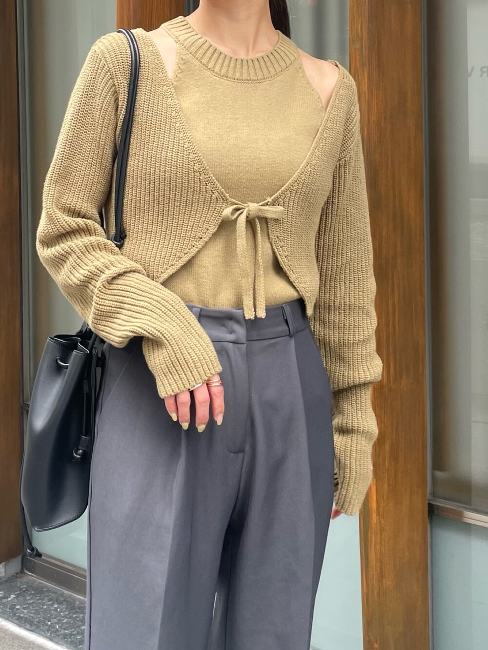 グリーン系のニット/セーターを着用したレディースの夏コーディネートの2枚目の写真