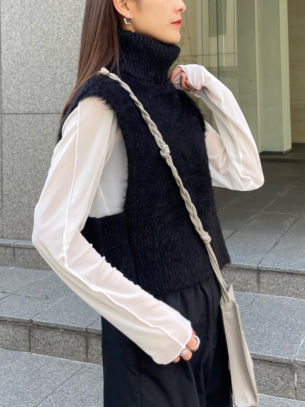 ブラック系のベスト、ホワイト系のTシャツ/カットソー、ブラック系のカーゴパンツを着用したレディースの秋コーディネートの2枚目の写真