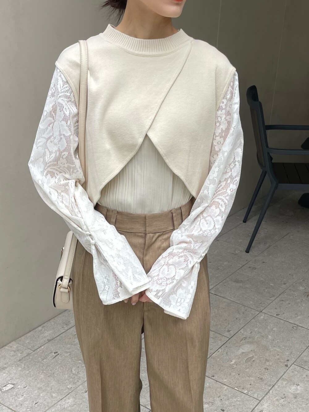 ホワイト系のニット/セーター、ベージュ系のスラックスを着用したレディースの冬コーディネートの3枚目の写真