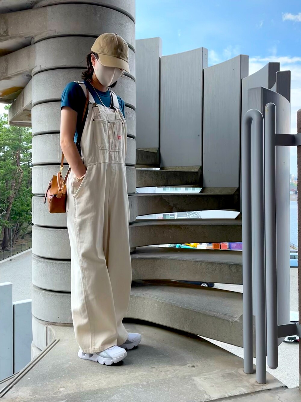 ホワイト系のサロペット/オーバーオール、ブルー系のTシャツ/カットソー、ホワイト系のスニーカーを着用したレディースの秋コーディネートの3枚目の写真