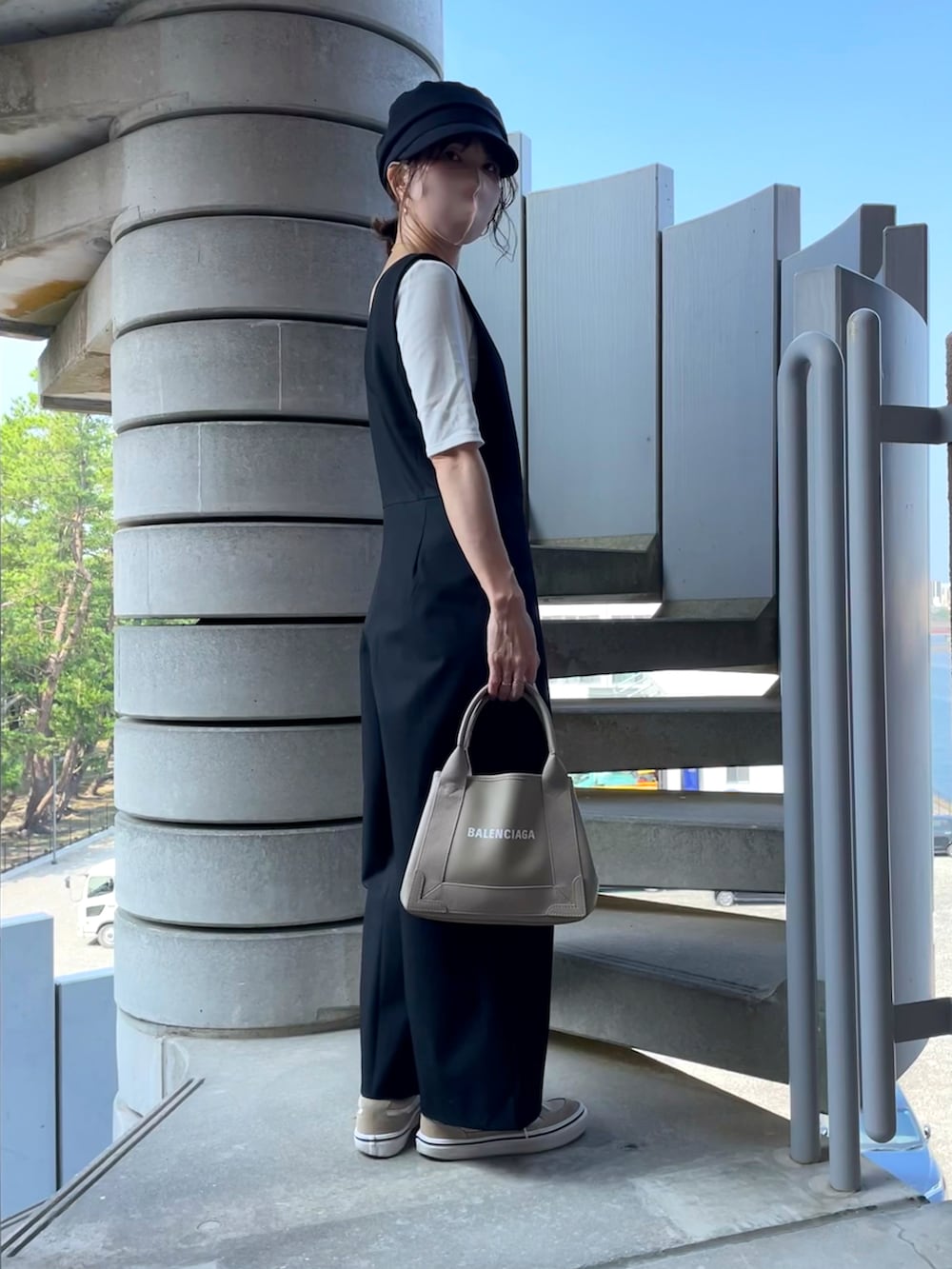 ホワイト系のTシャツ/カットソー、ブラック系のオールインワン・サロペット、ベージュ系のショルダーバッグを着用したレディースの秋コーディネートの2枚目の写真