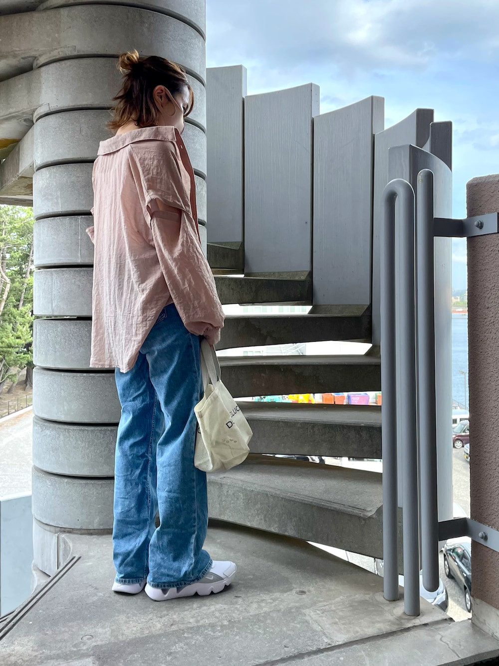 ピンク系のシャツ/ブラウス、ブルー系のデニムパンツ、ホワイト系のスニーカーを着用したレディースの秋コーディネートの2枚目の写真