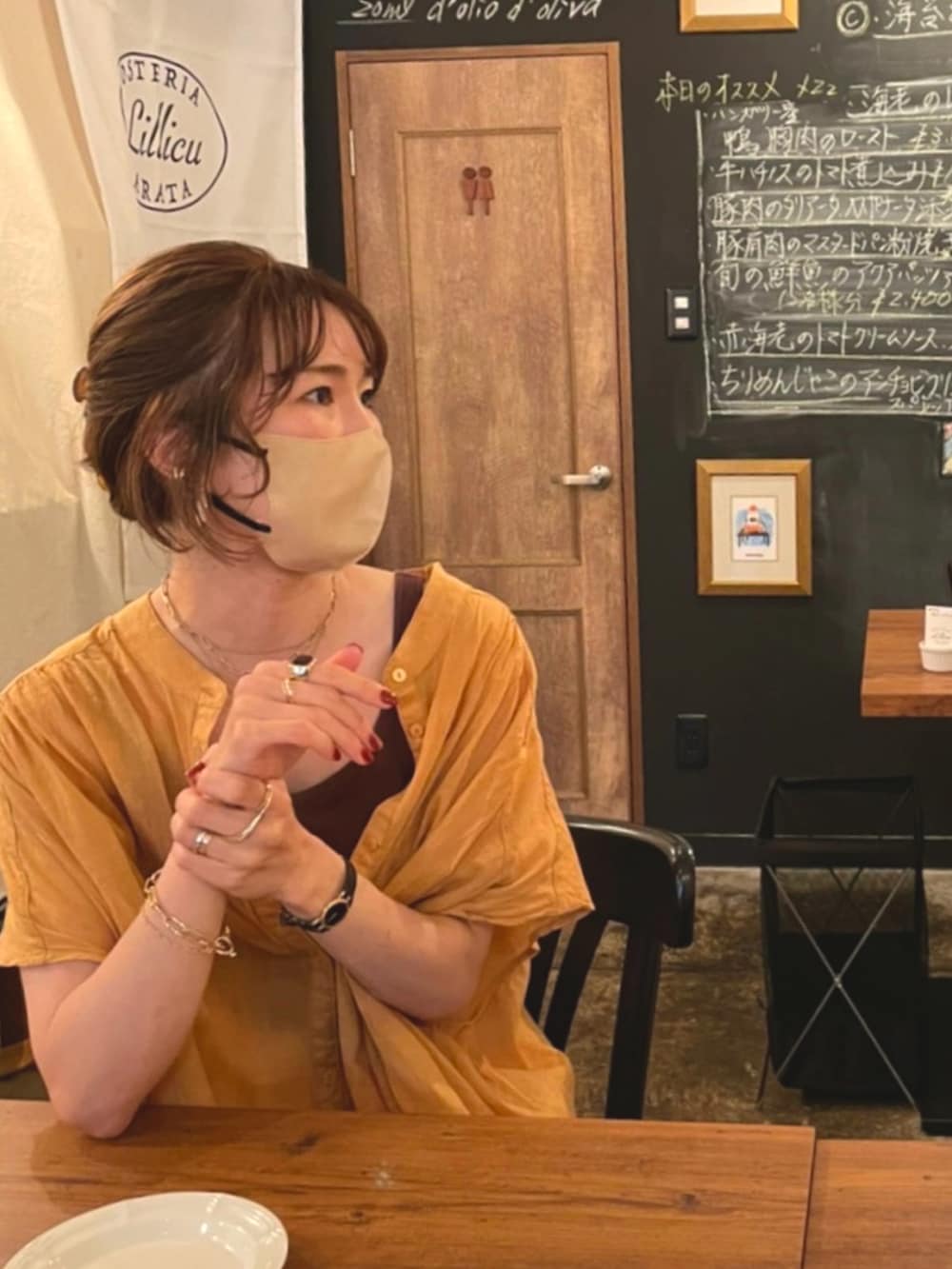 イエロー系のシャツ/ブラウス、ブラウン系のハンドバッグ、ブラウン系のタンクトップを着用したレディースの夏コーディネートの2枚目の写真