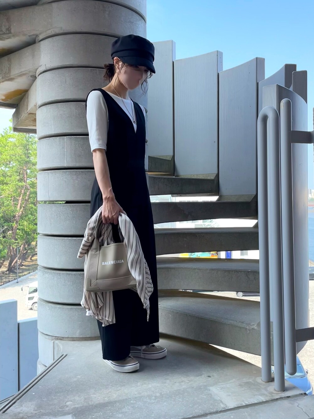 ホワイト系のTシャツ/カットソー、ブラック系のオールインワン・サロペット、ベージュ系のショルダーバッグを着用したレディースの秋コーディネートの3枚目の写真