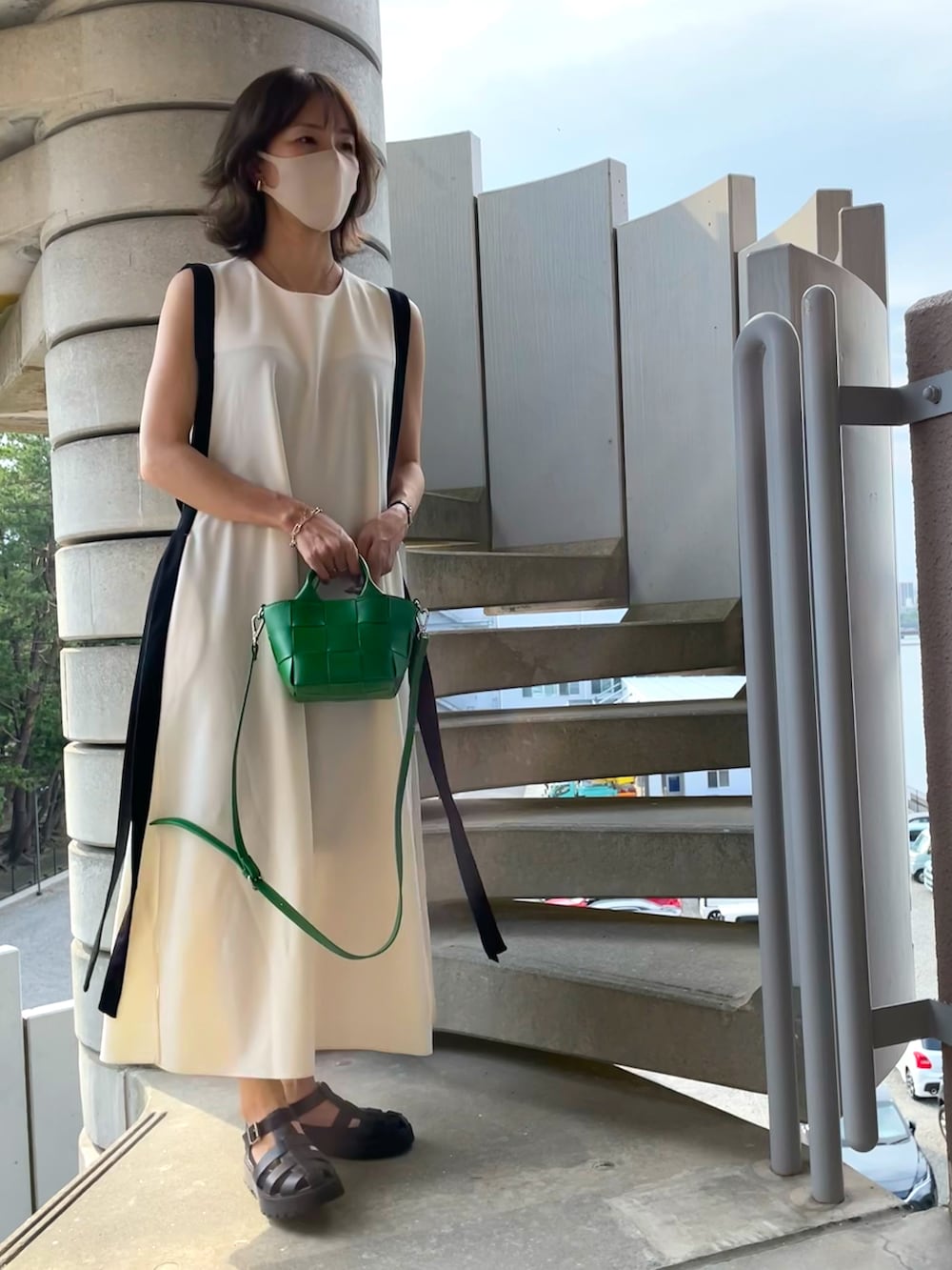 ホワイト系のワンピース、ブラック系のサンダル、グリーン系のショルダーバッグを着用したレディースの秋コーディネートの2枚目の写真